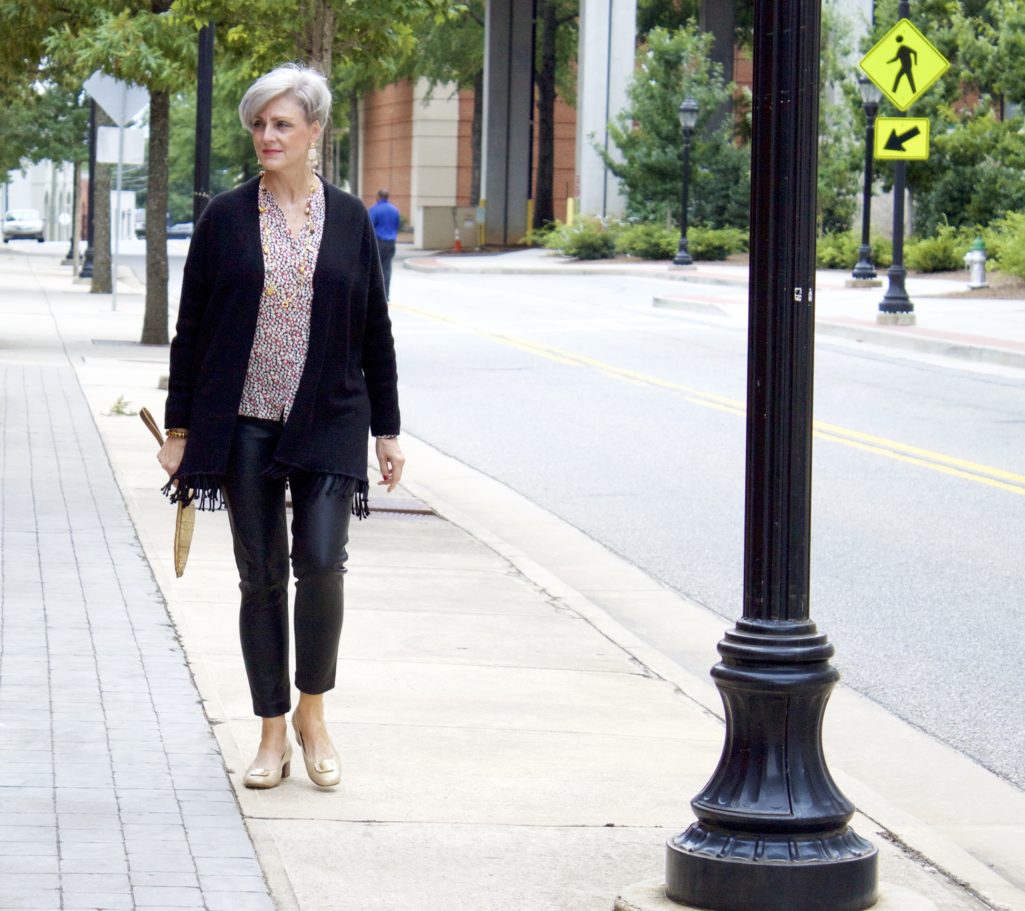 enjoying sweater weather in faux leather leggings, silk blouse and fring cardigan by style at a certain age