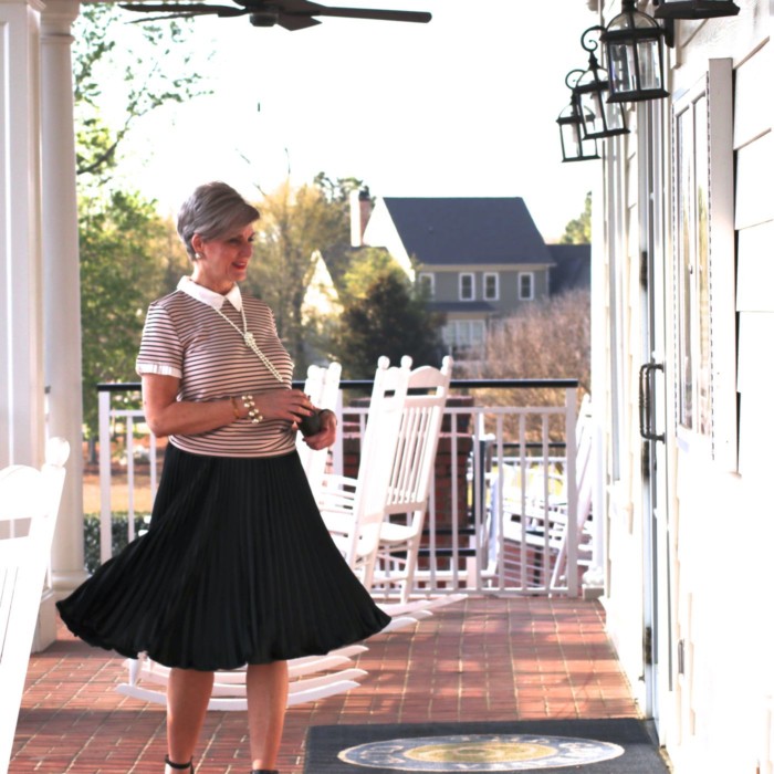 karl lagerfeld striped blouse black pleated skirt, black sandals, clutch