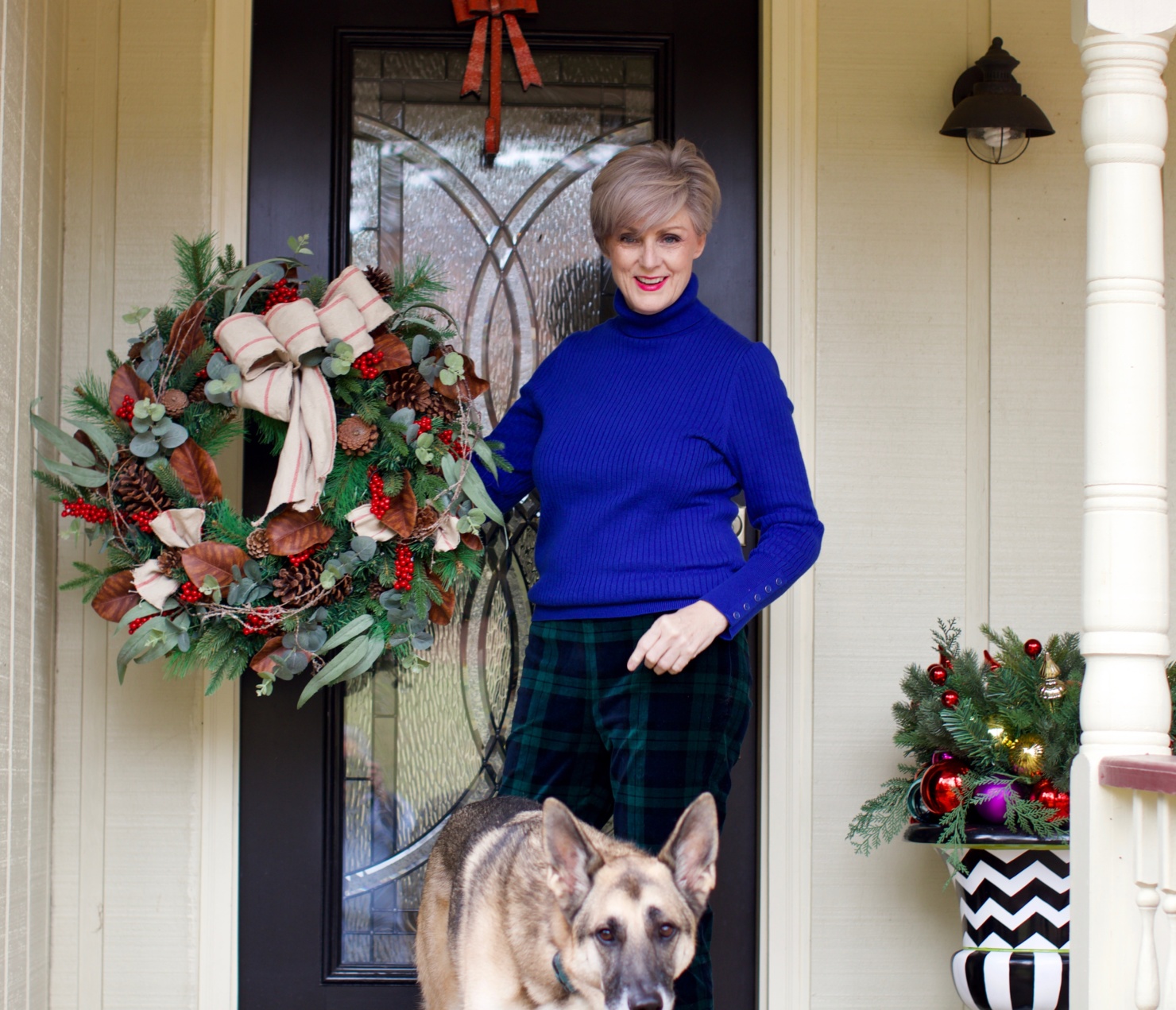 beth from Style at a Certain age wears velveteen black watch plaid pants, blue ribbed turtleneck, and loafers