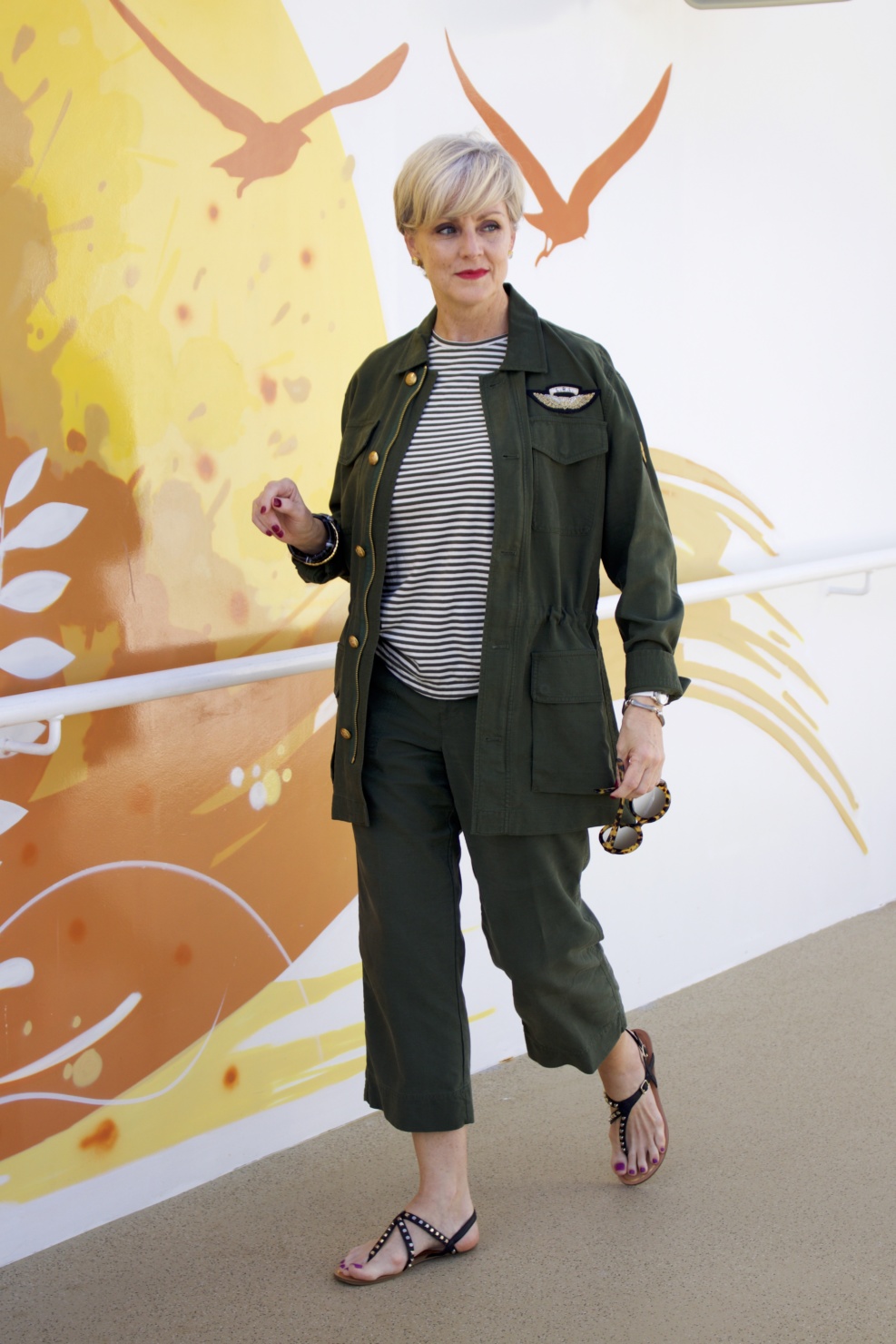 beth from Style at a Certain Age wears a Ralph Lauren military jacket, striped tee, and green cropped pants