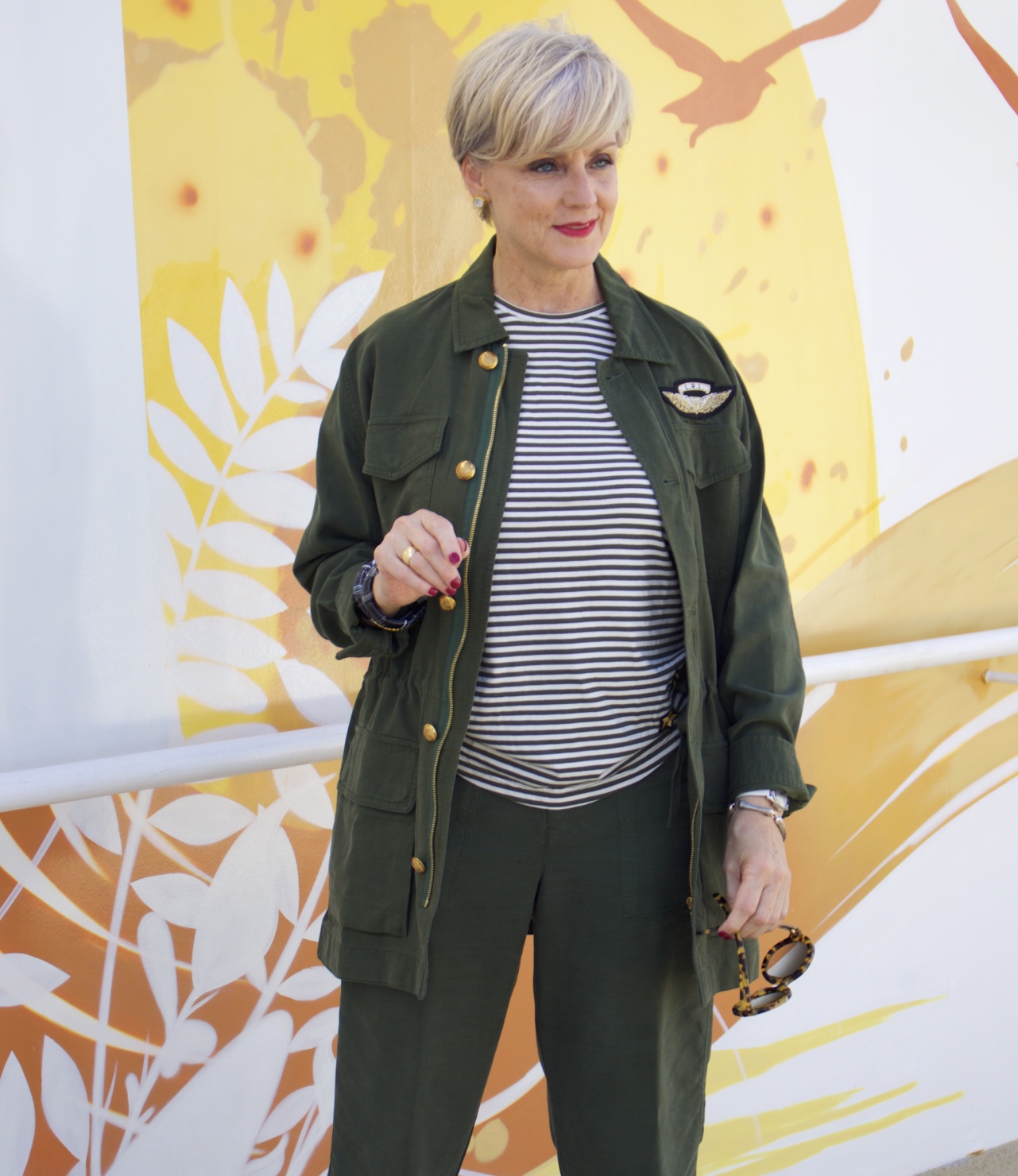 beth from Style at a Certain Age wears a Ralph Lauren military jacket, striped tee, and green cropped pants
