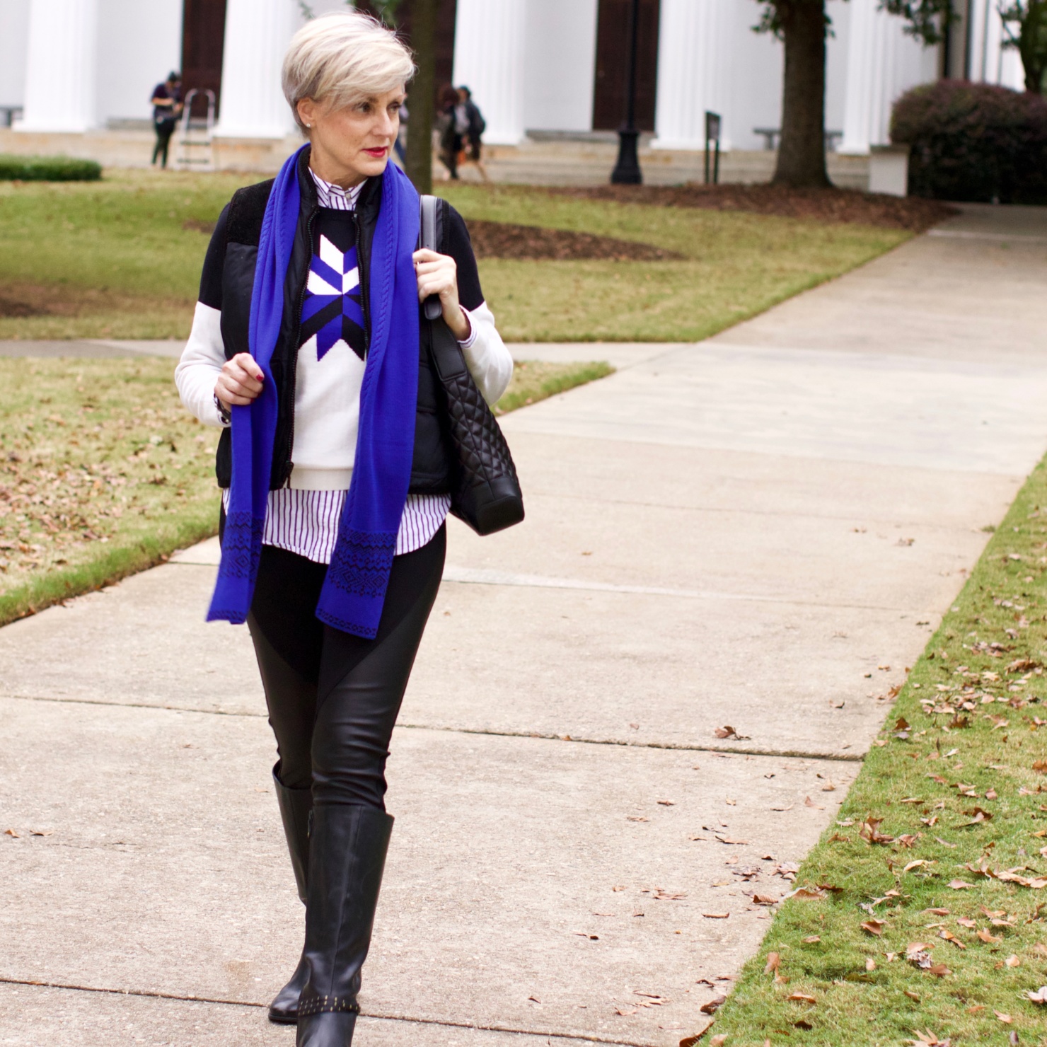 beth from Style at a Certain Age wears a snowflake intarsia sweater, DKNY ponte leggings, striped shirt, riding boots, and a cobalt blue intarsia trim scarf