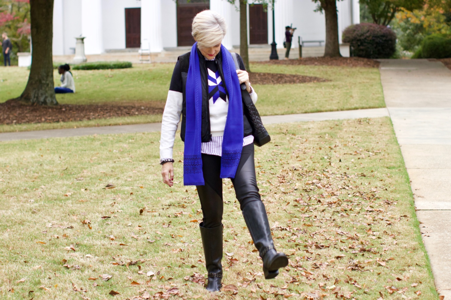 beth from Style at a Certain Age wears a snowflake intarsia sweater, DKNY ponte leggings, striped shirt, riding boots, and a cobalt blue intarsia trim scarf
