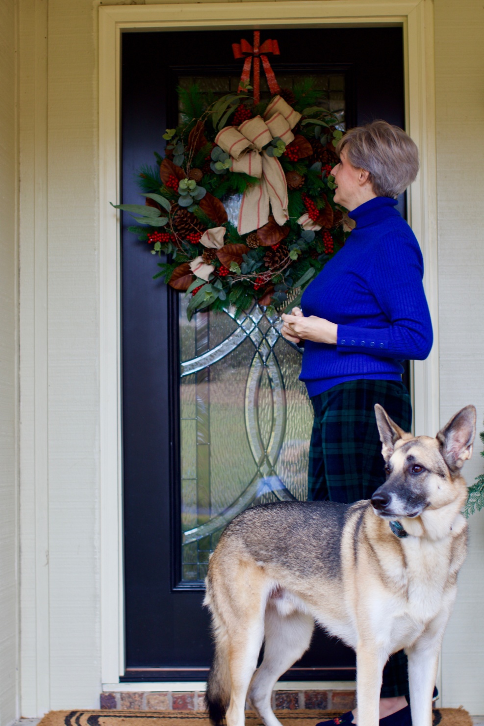 beth from Style at a Certain age wears velveteen black watch plaid pants, blue ribbed turtleneck, and loafers
