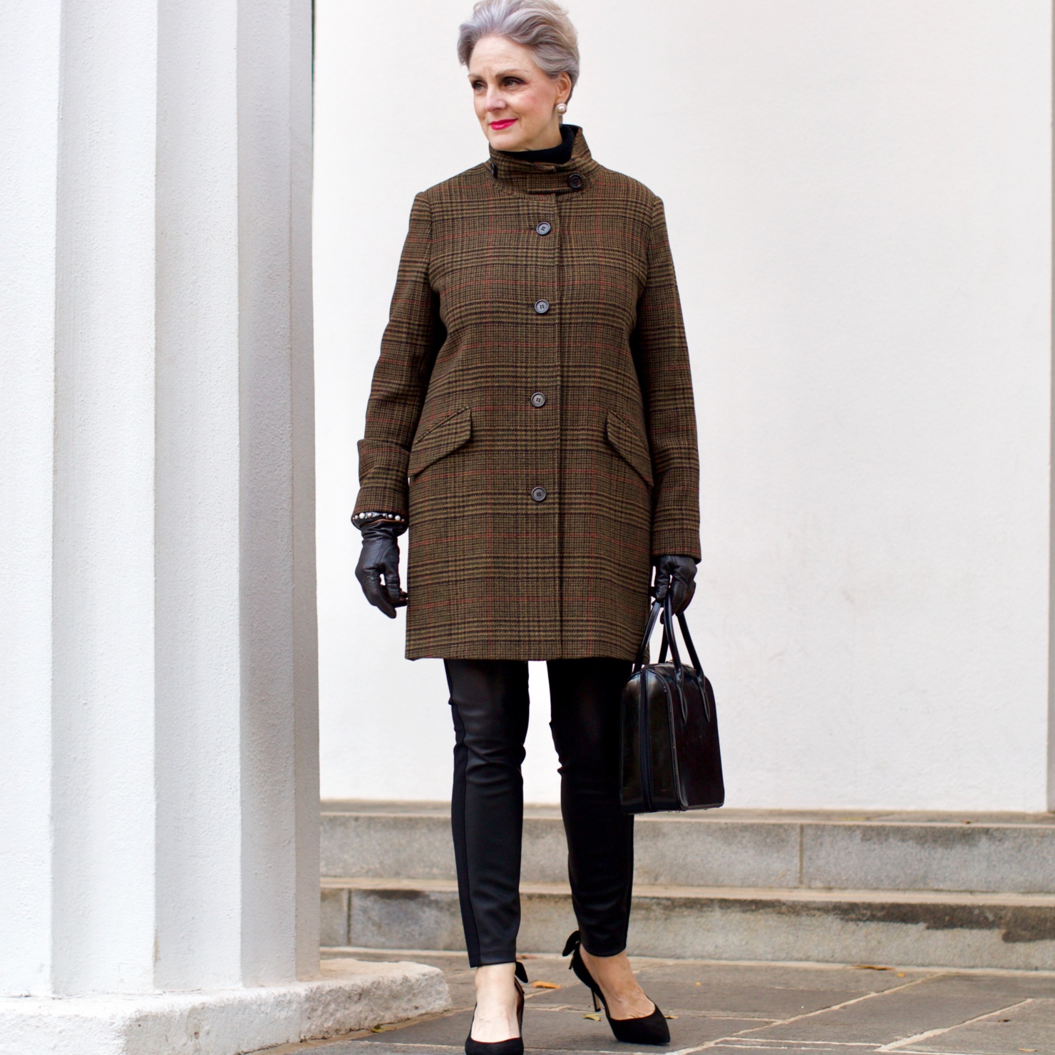 beth from Style at a Certain Age wears a black cashmere Turtleneck dress, faux leather leggings and suede pumps.