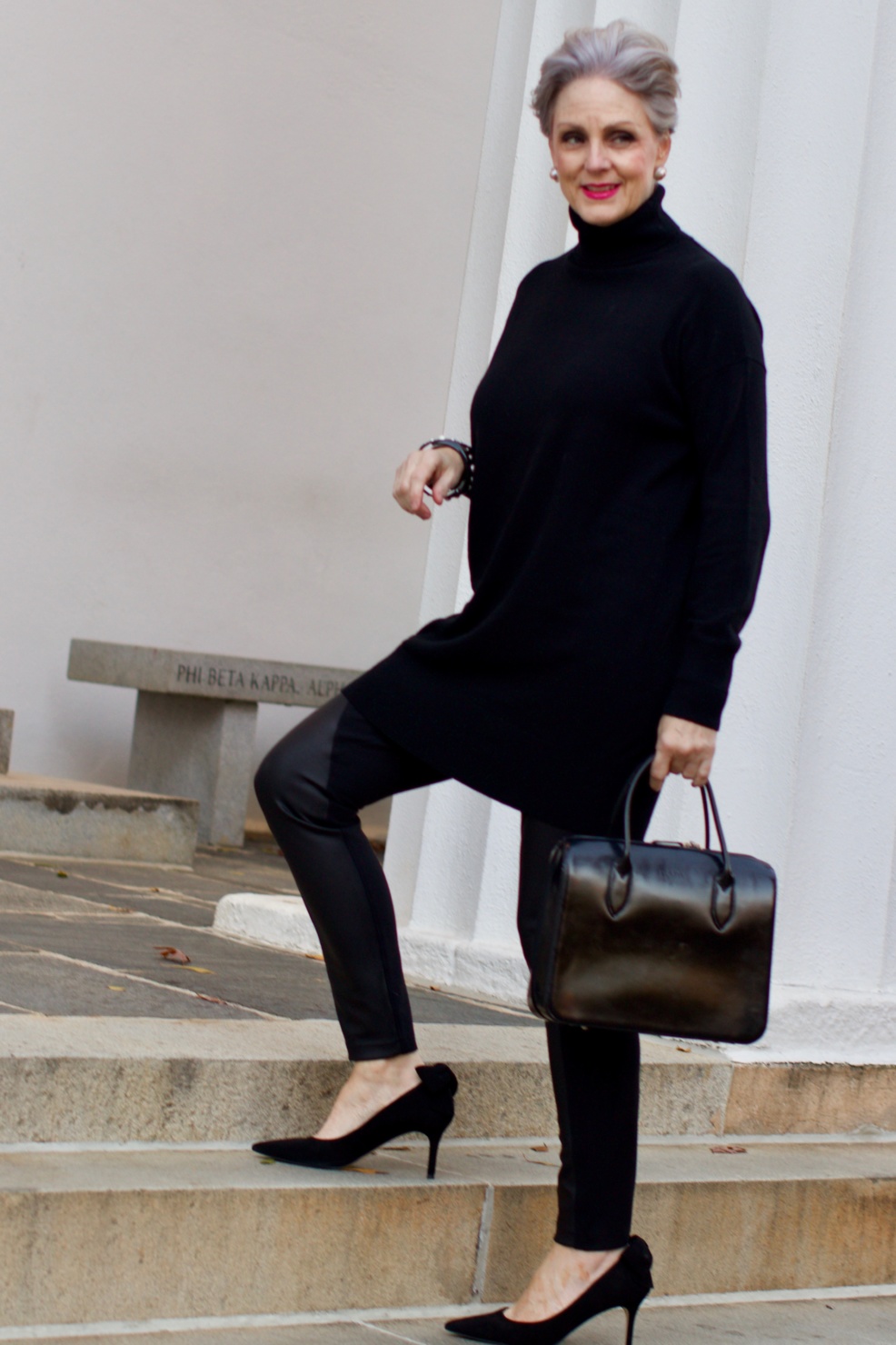 beth from Style at a Certain Age wears a black cashmere Turtleneck dress, faux leather leggings and suede pumps.