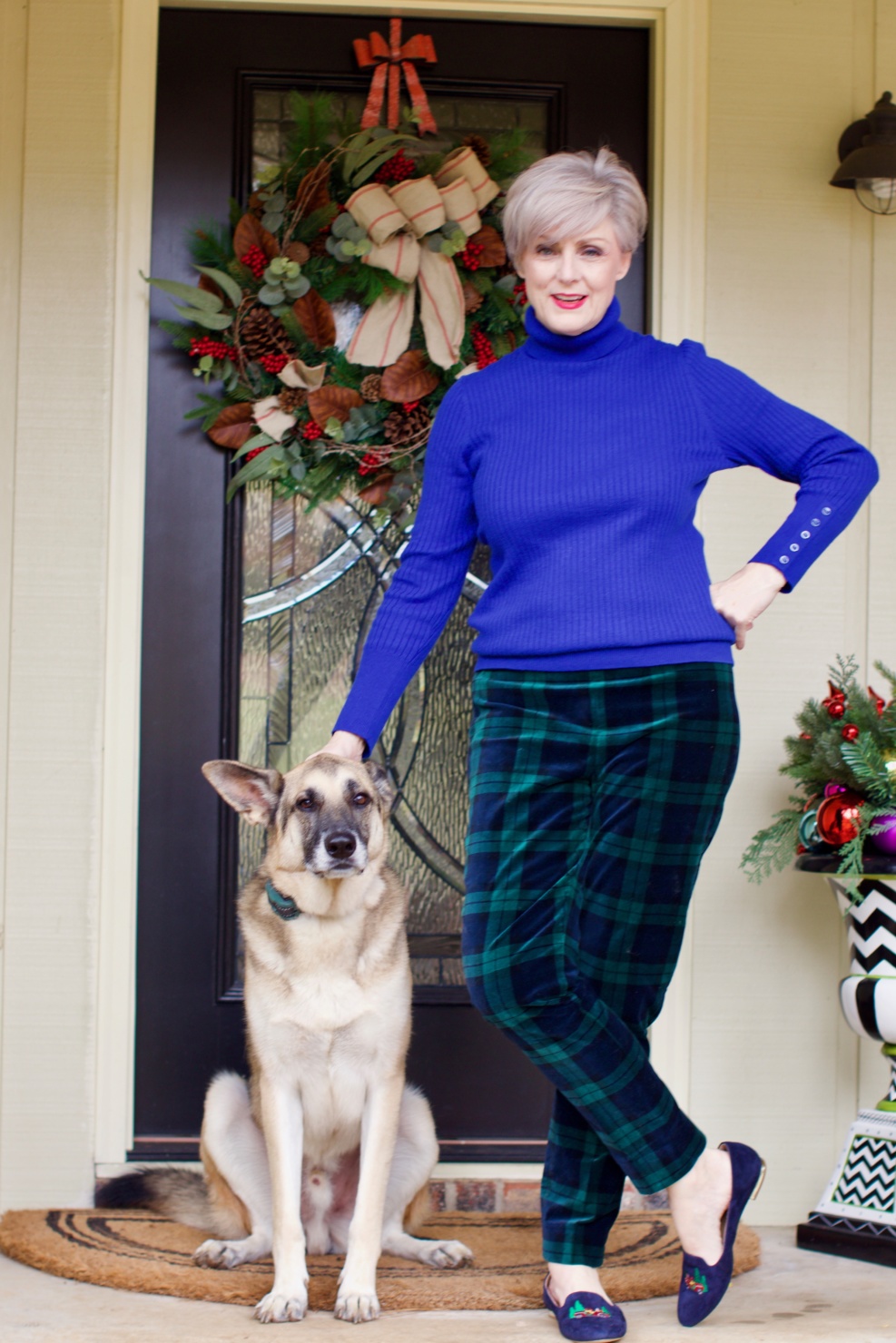beth from Style at a Certain age wears velveteen black watch plaid pants, blue ribbed turtleneck, and loafers