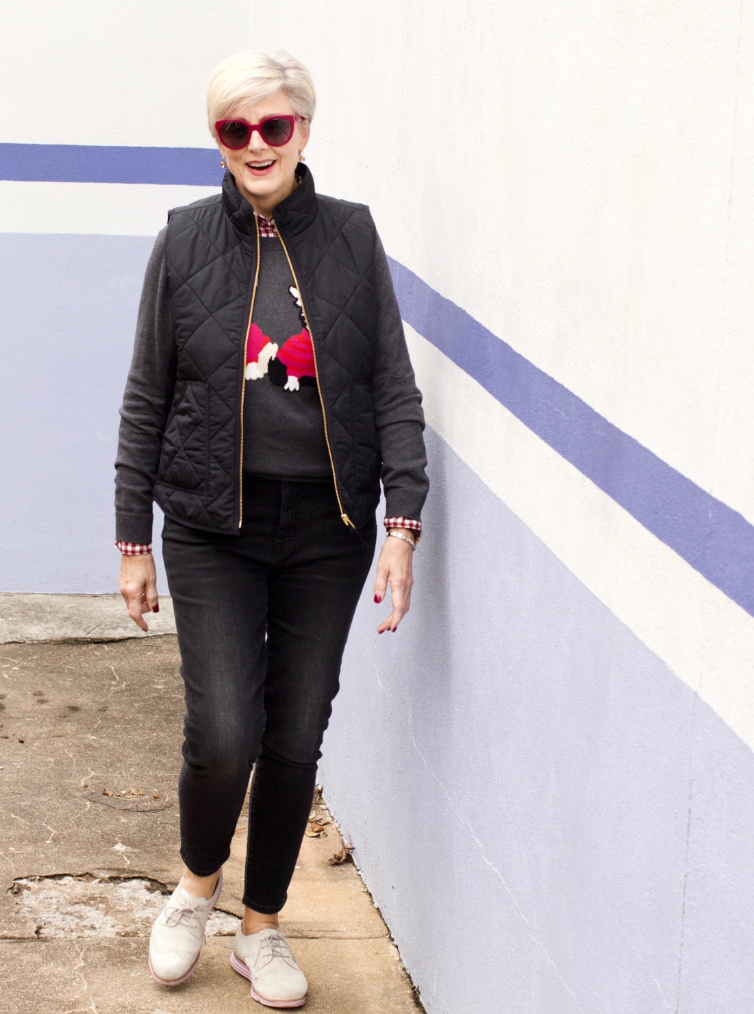 beth from Style at a Certain Age wears a J.Crew Factory high rise skinny jean, burgundy check shirt, french bulldog teddie sweater, quilted puffer jacket