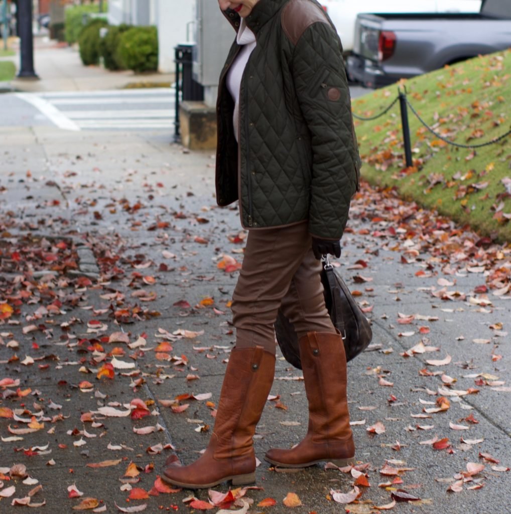 beth from Style at a Certain Age is wearing Ralph Lauren faux leather pants, chunky cashmere sweater, green utility jacket, Frye boots, and Frye hobo handbag