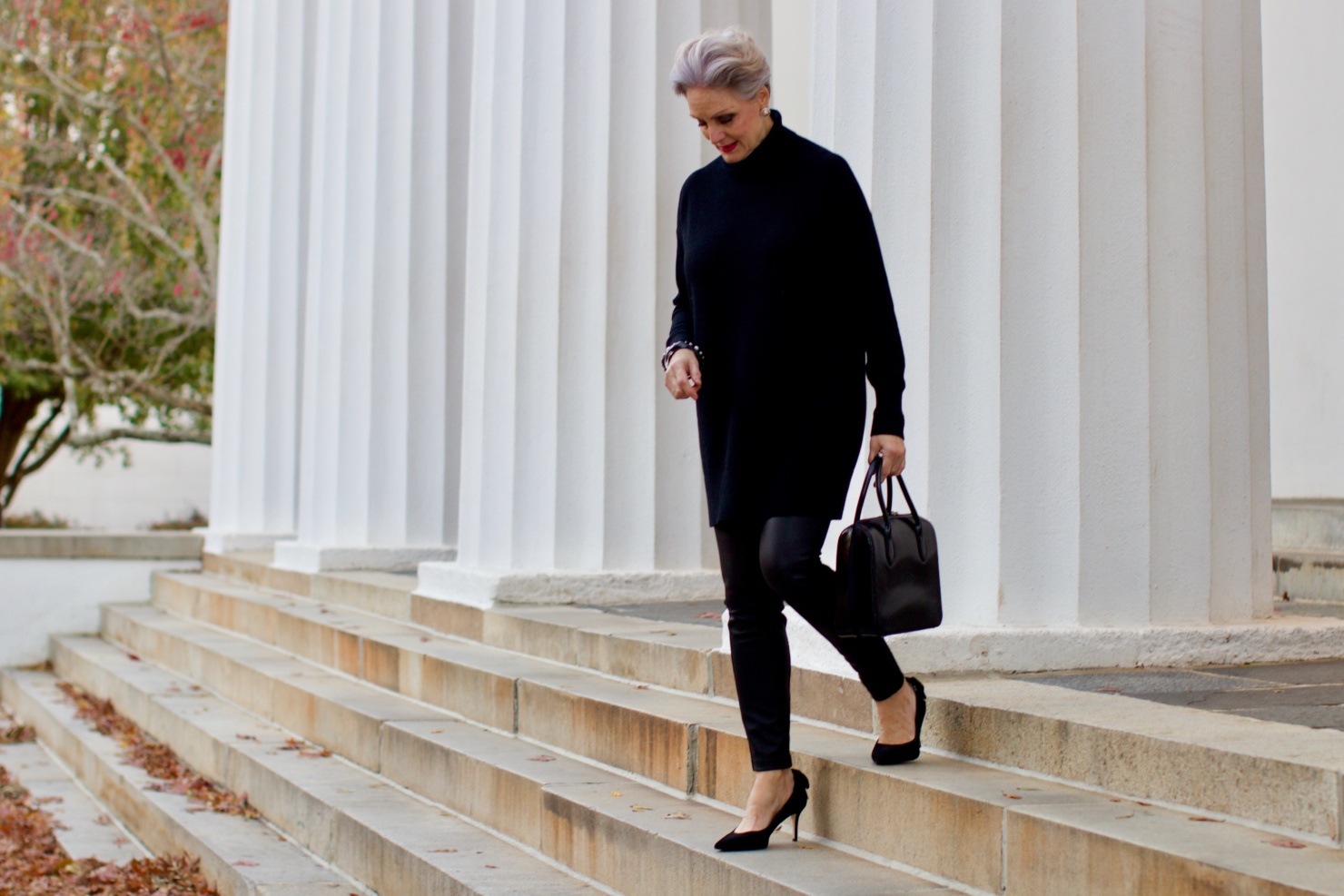 beth from Style at a Certain Age wears a black cashmere Turtleneck dress, faux leather leggings and suede pumps.