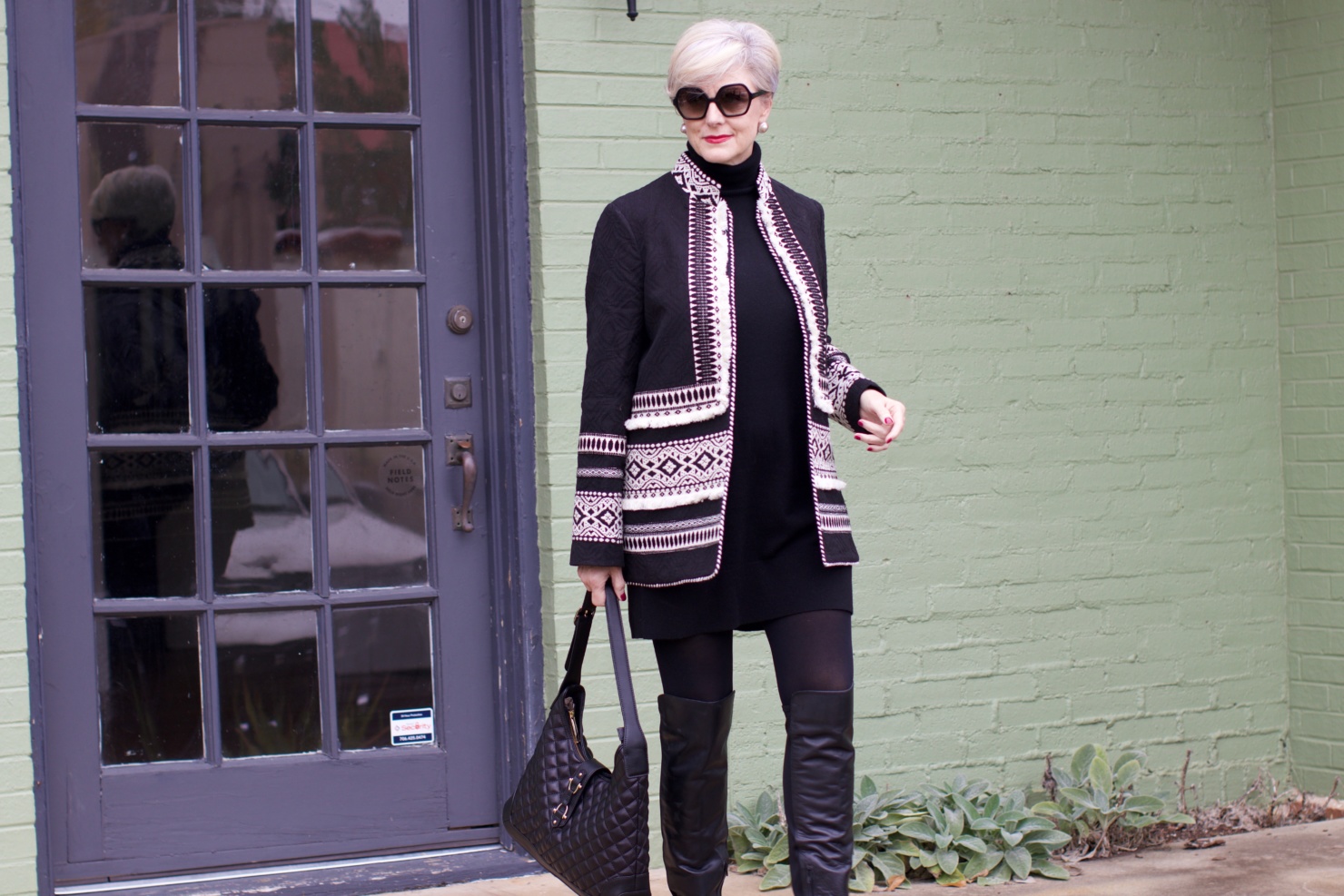 beth from style at a certain age wears a cashmere sweater dress from everlane, anthropologie embroidered jacket, black over the knee boots