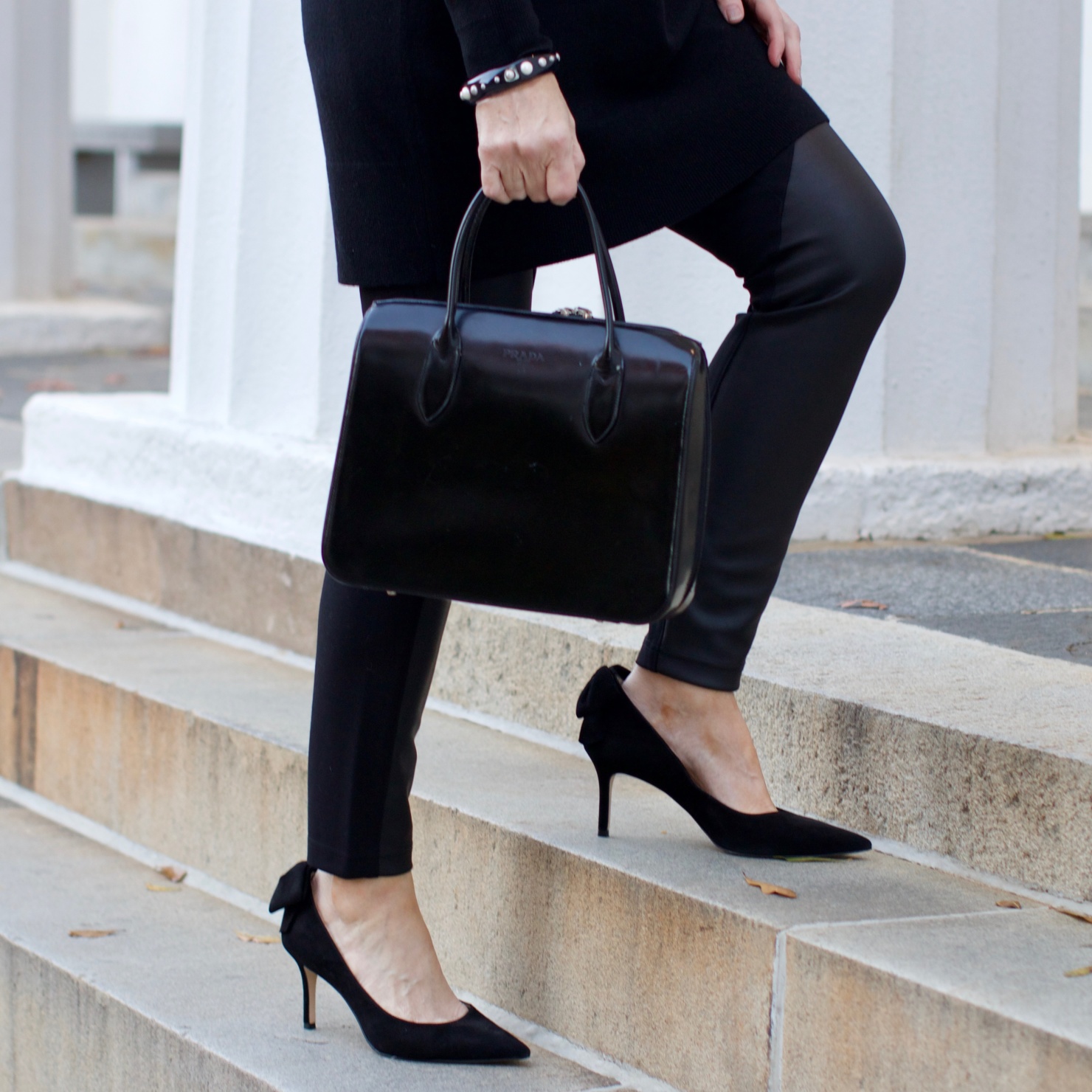 beth from Style at a Certain Age wears a black cashmere Turtleneck dress, faux leather leggings and suede pumps.