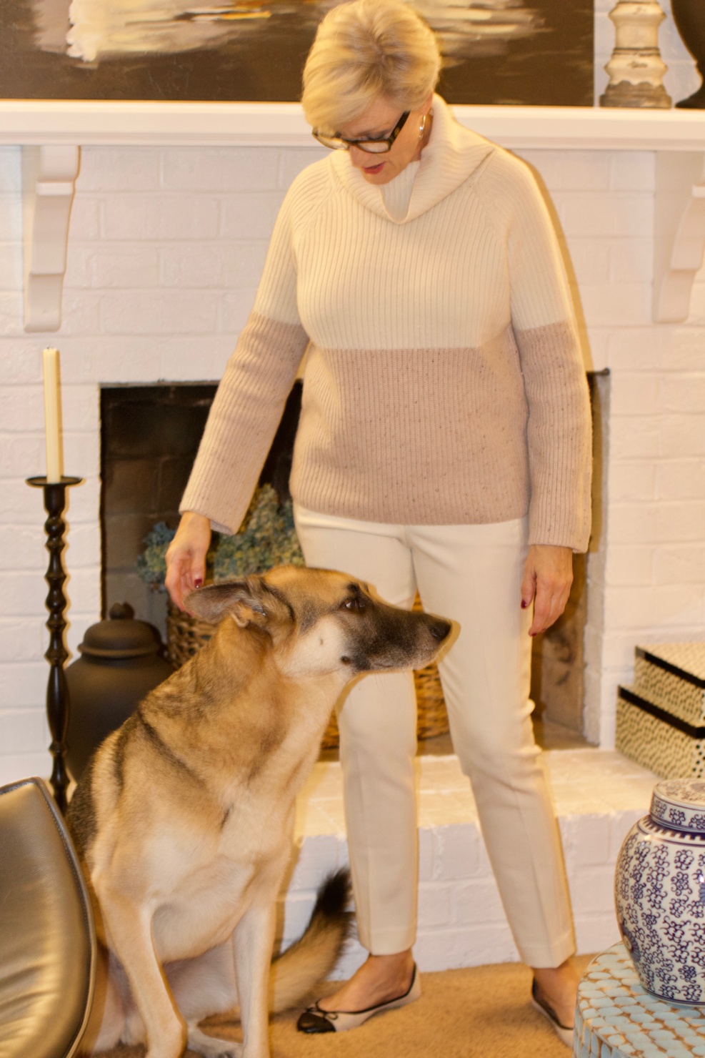 beth from Style at a Certain Age wears a cashmere color block sweater, slim leg ivory pants, cap toe ballet flats