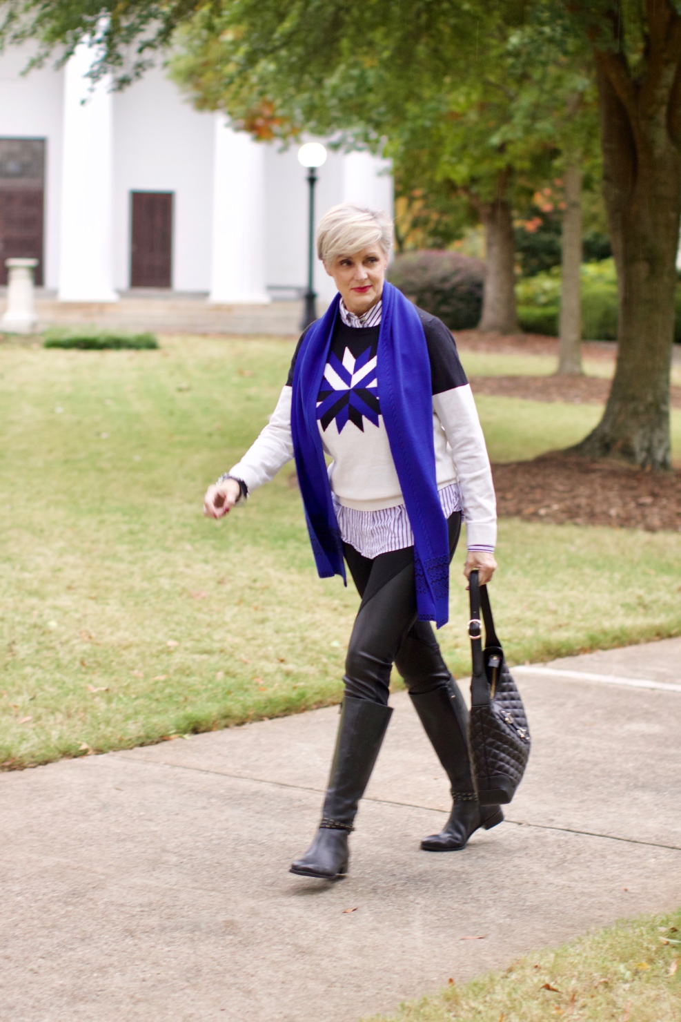 beth from Style at a Certain Age wears a snowflake intarsia sweater, DKNY ponte leggings, striped shirt, riding boots, and a cobalt blue intarsia trim scarf