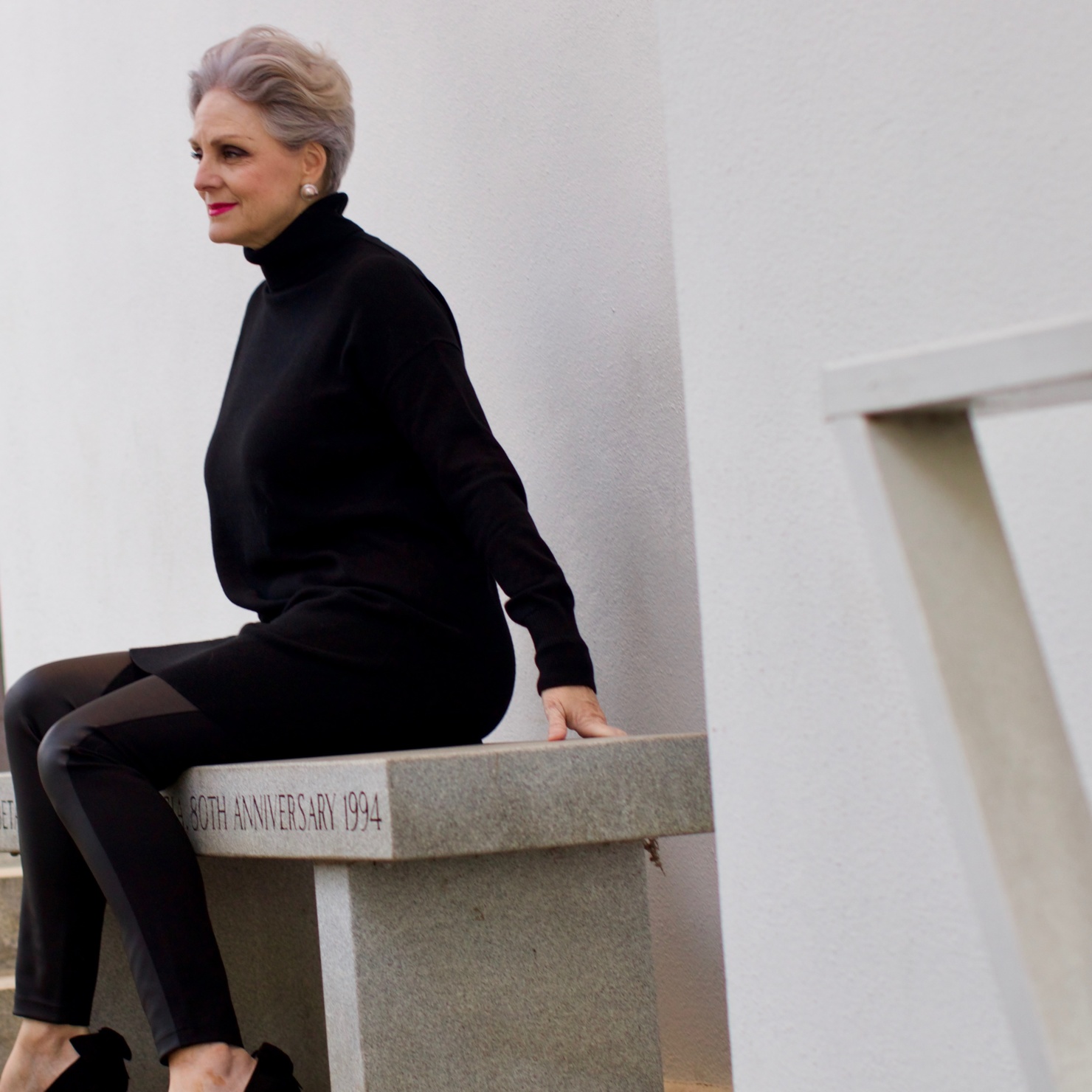 beth from Style at a Certain Age wears a black cashmere Turtleneck dress, faux leather leggings and suede pumps.