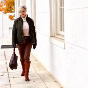 beth from Style at a Certain Age is wearing Ralph Lauren faux leather pants, chunky cashmere sweater, green utility jacket, Frye boots, and Frye hobo handbag