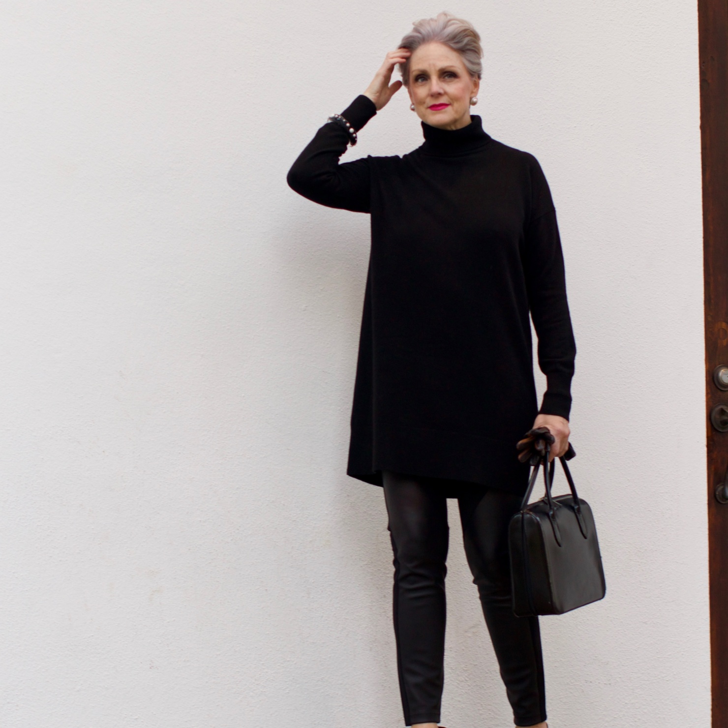 beth from Style at a Certain Age wears a black cashmere Turtleneck dress, faux leather leggings and suede pumps.