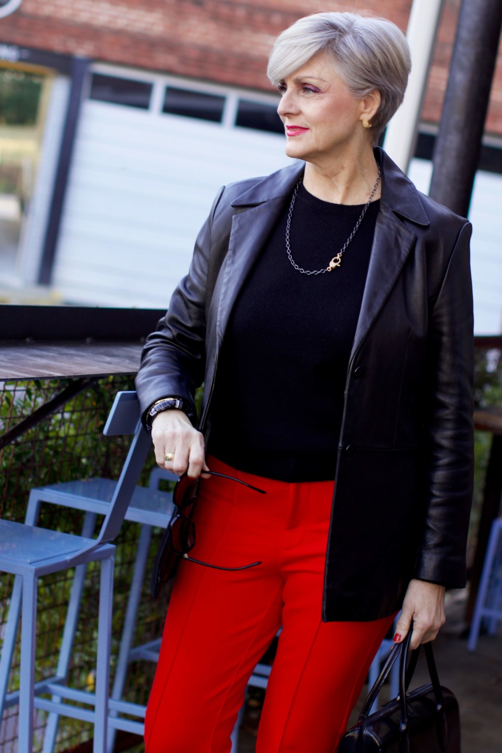 beth from Style at a Certain Age wears Anthropologie red pants, Everlane black cashmere crewneck, black leather blazer, and leopard pumps