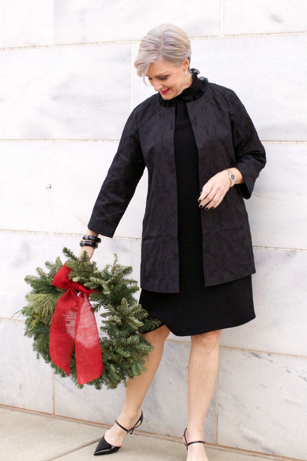 beth from Style at a Certain Age wears a Eileen Fisher shimmer jacquard 3/4 sleeve jacket and ruffled black dress 