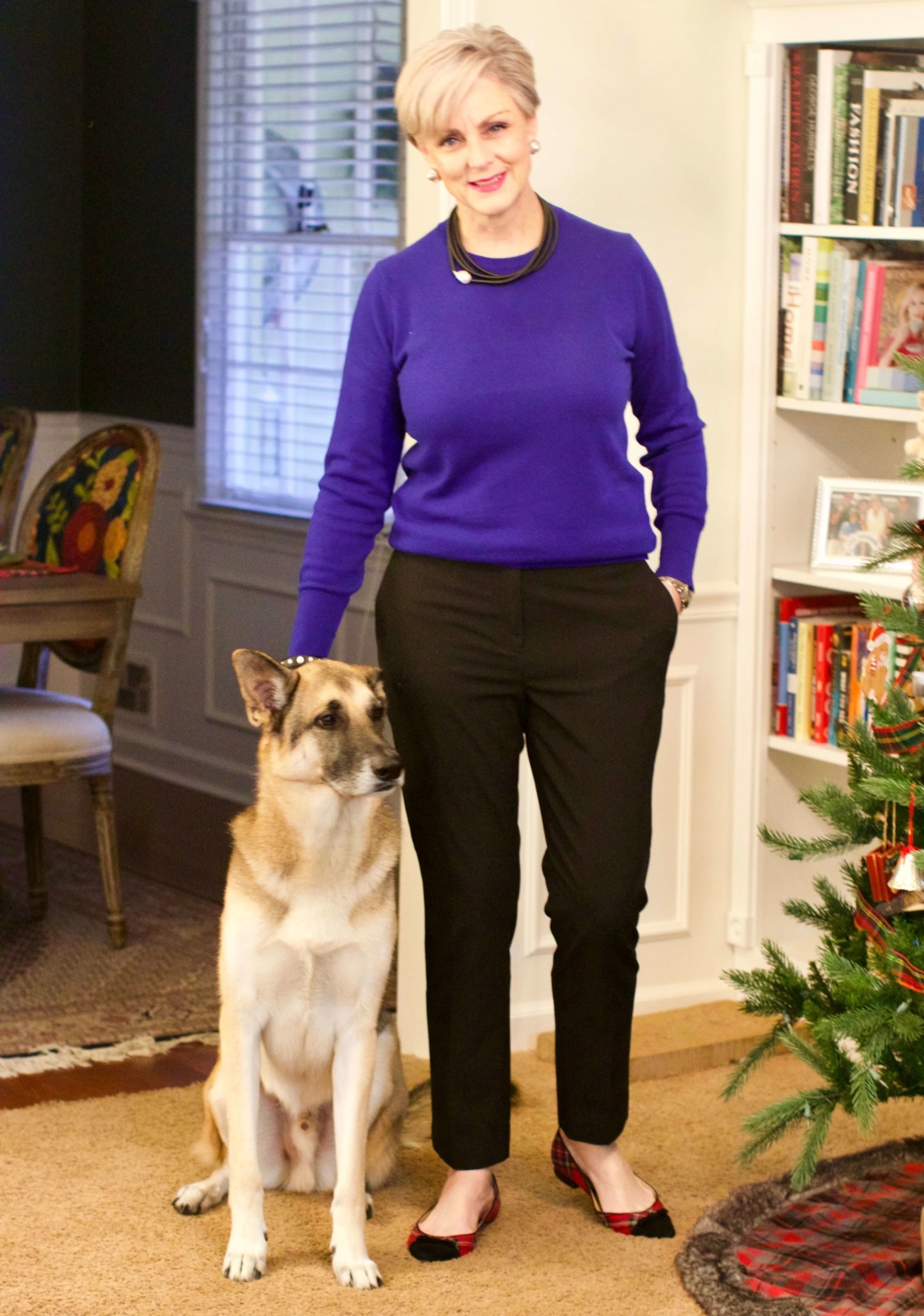beth from Style at a Certain Age wears a cobalt blue cashmere crewneck, cropped black ankle pants, and tartan plaid flats