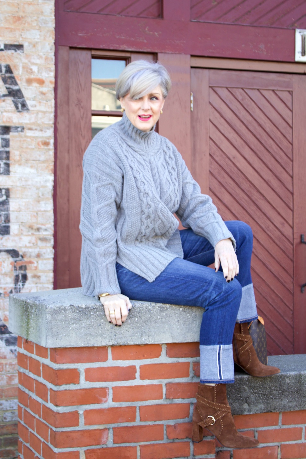 warm cozy sweater. beth from Style at a Certain Age wears blue jeans, cable knit sweater, and suede boots