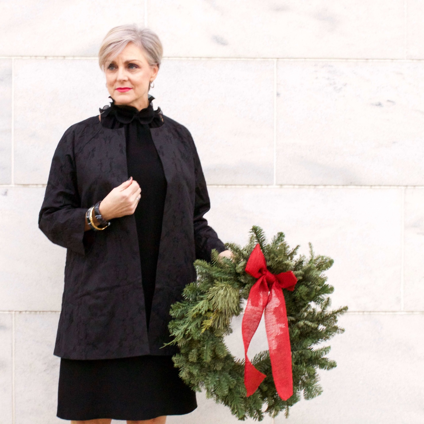 beth from Style at a Certain Age wears a Eileen Fisher shimmer jacquard 3/4 sleeve jacket and ruffled black dress 