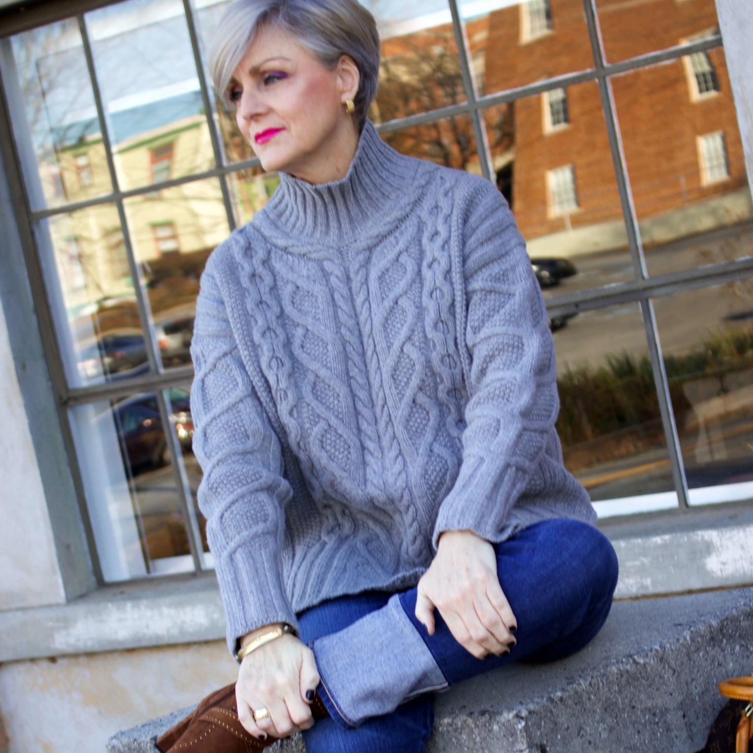 warm cozy sweater. beth from Style at a Certain Age wears a gray cable knit sweater from Everlane and cuffed denim from AG.