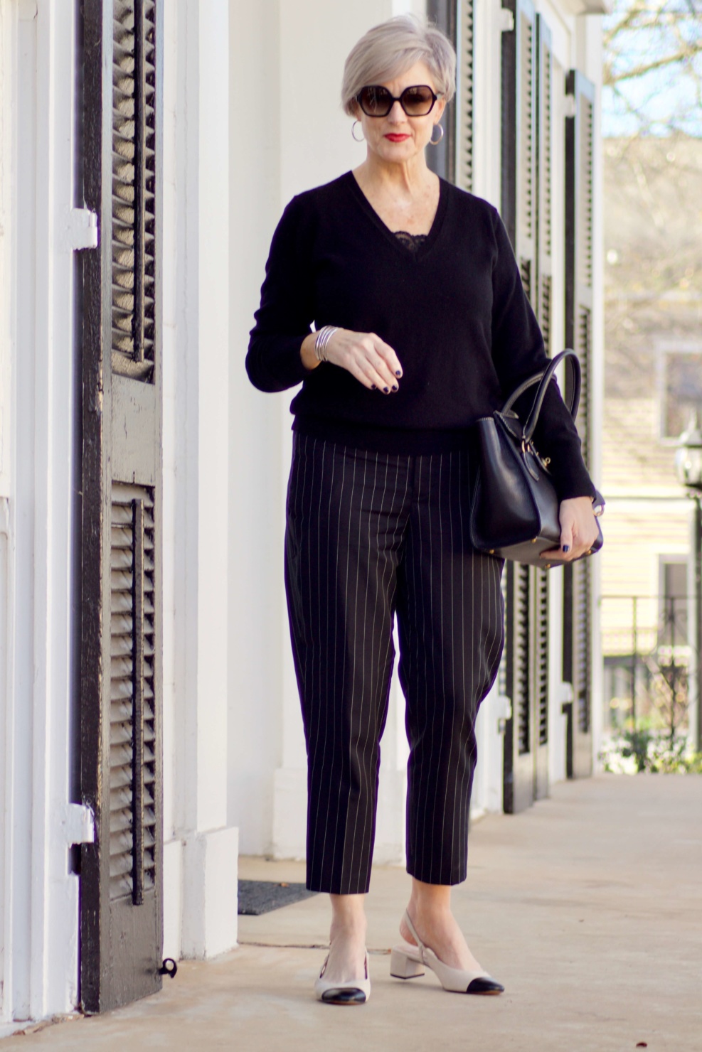 beth from Style at a Certain Age wears Ralph Lauren pinstripe pants, Everlane cashmere sweater, black leather moto jacket, and cap toe slingbacks