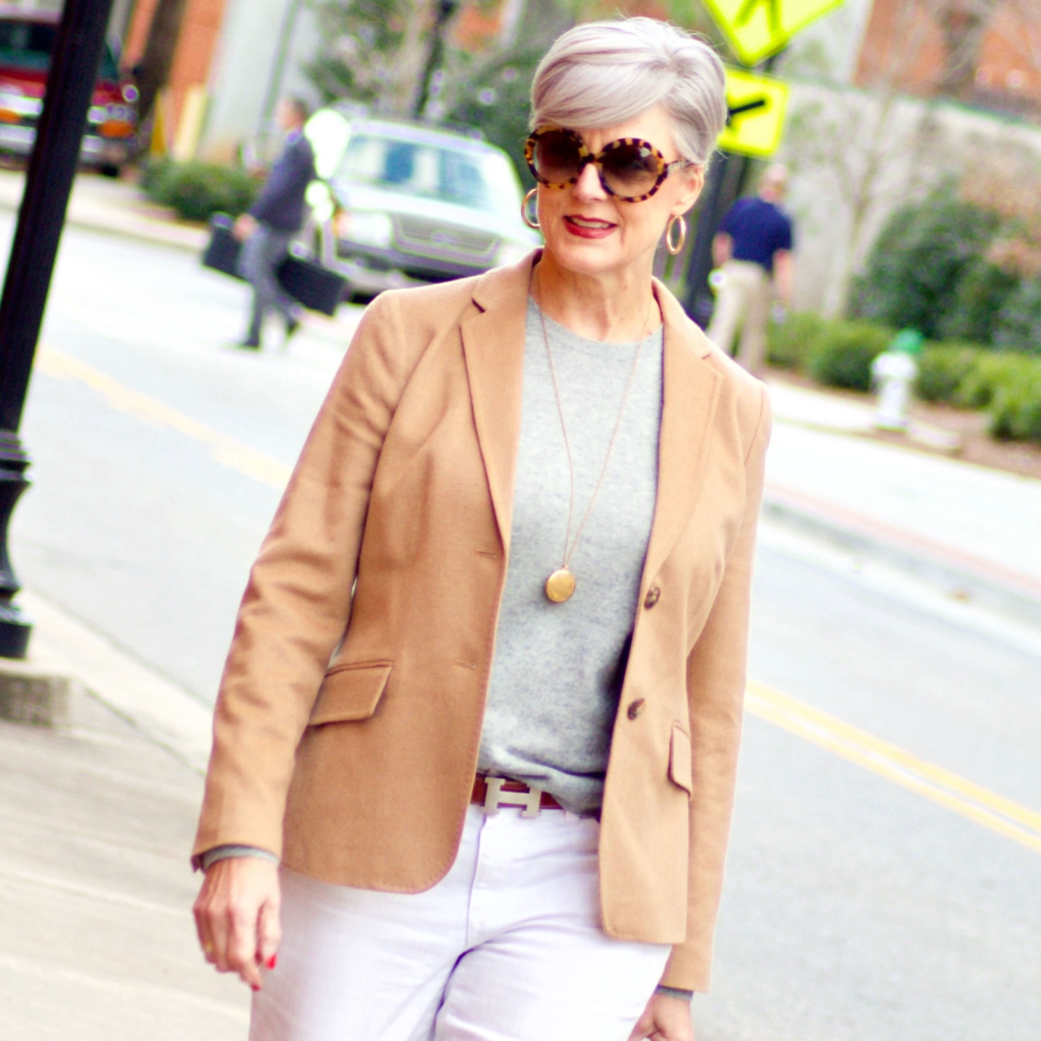 beth from Style at a Certain Age wears a camel blazer, grey cashmere crewneck, white denim, and leopard shoes