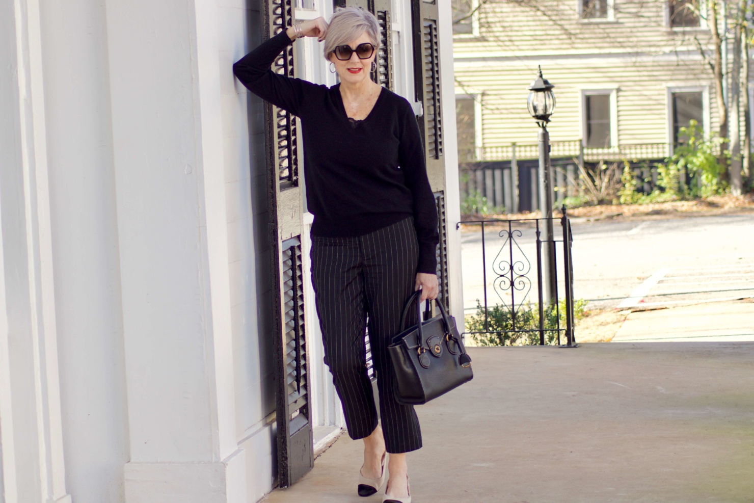 beth from Style at a Certain Age wears Ralph Lauren pinstripe pants, Everlane cashmere sweater, black leather moto jacket, and cap toe slingbacks