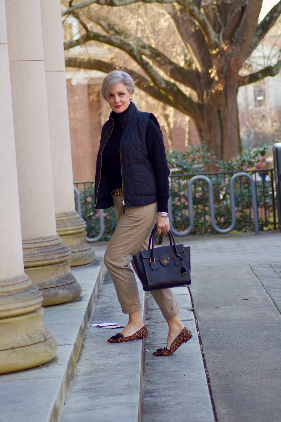 beth from Style at a Certain Age wears J.Crew polka dot chinos, Everlane cashmere waffle turtleneck, J.Crew Factory puffer vest, and Ann Taylor leopard flats