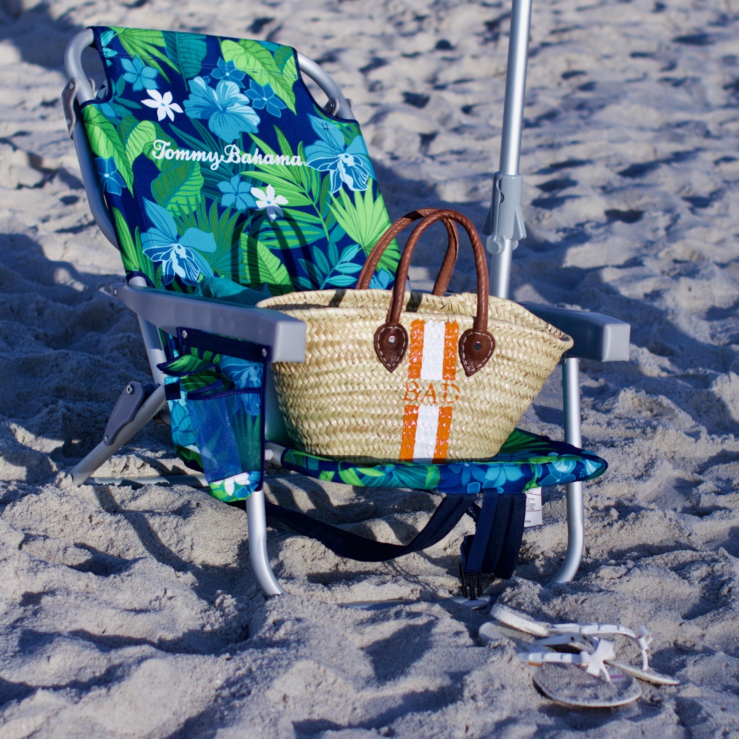 beth from Style at a Certain Age wears beach essentials, Ralph Lauren striped one-piece swimsuit, Tory Burch cover-up, jelly flip-flops, panama hat, and straw tote