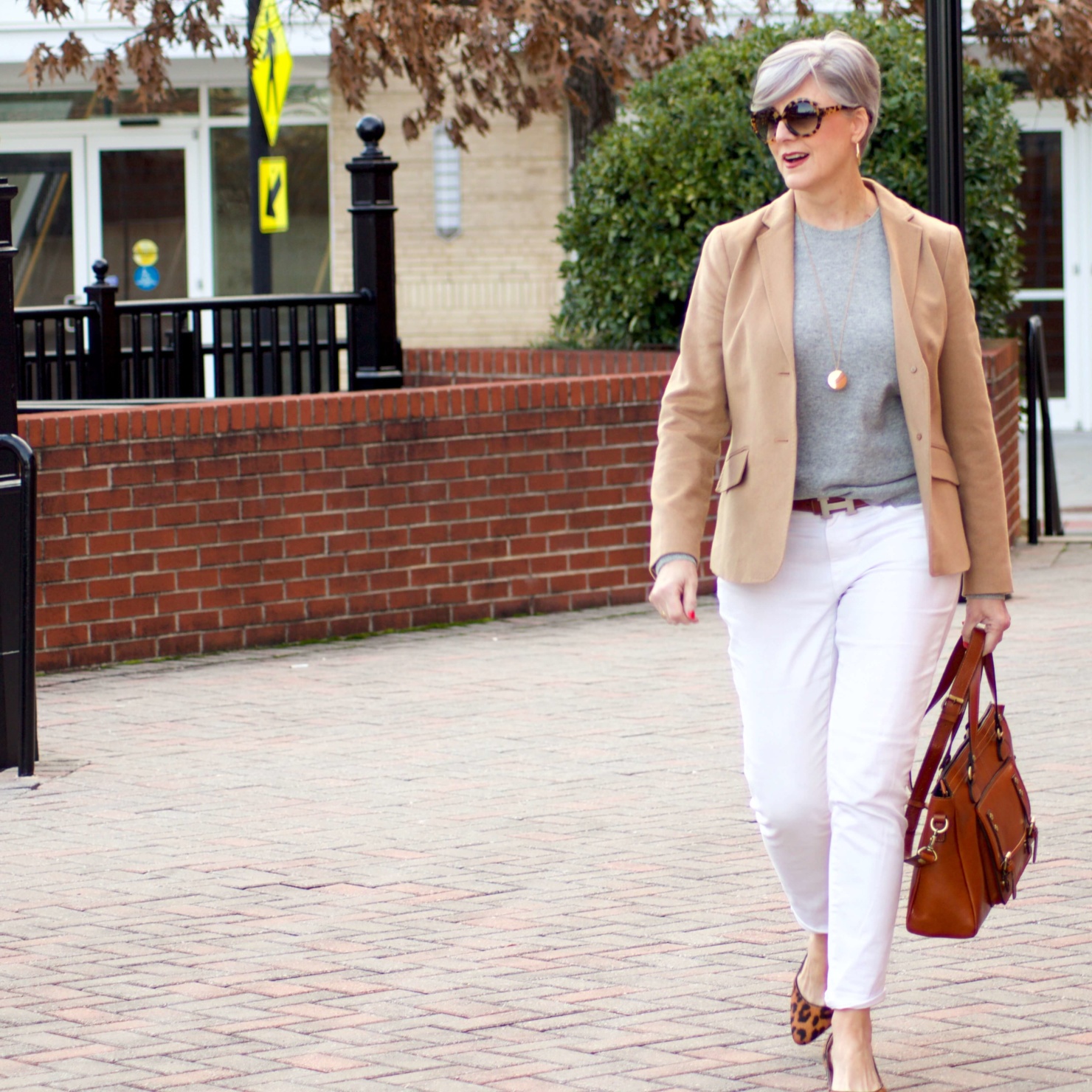 beth from Style at a Certain Age wears a camel blazer, grey cashmere crewneck, white denim, and leopard shoes