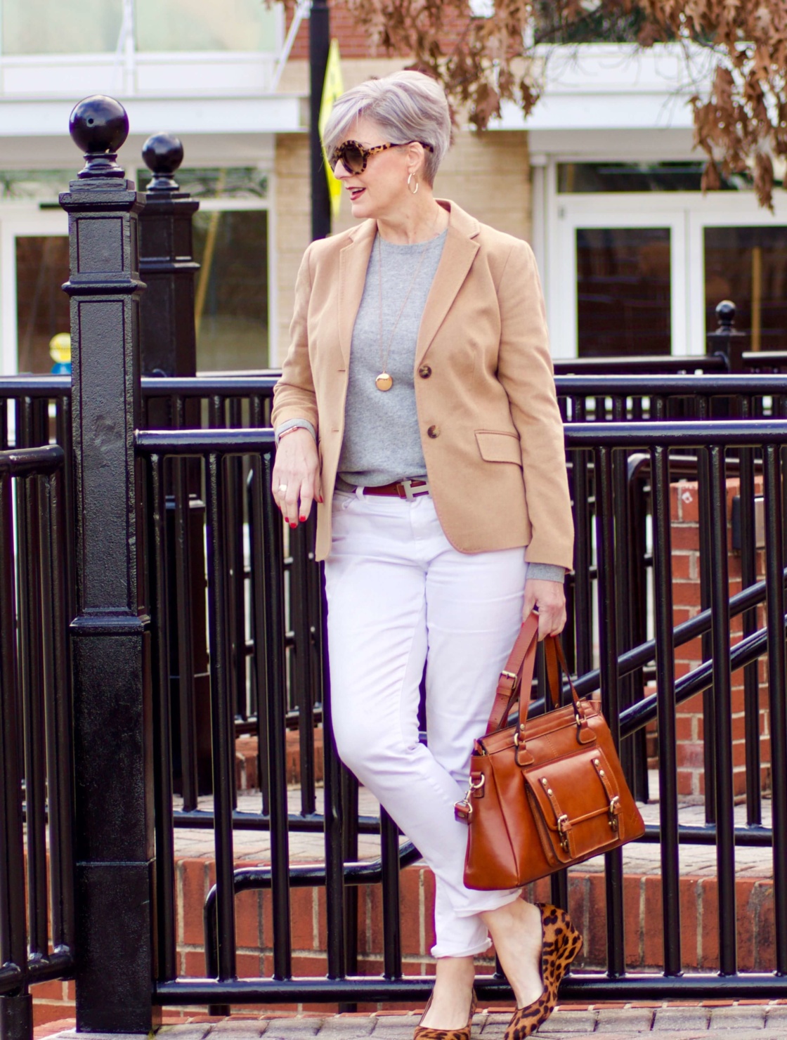 beth from Style at a Certain Age wears a camel blazer, grey cashmere crewneck, white denim, and leopard shoes