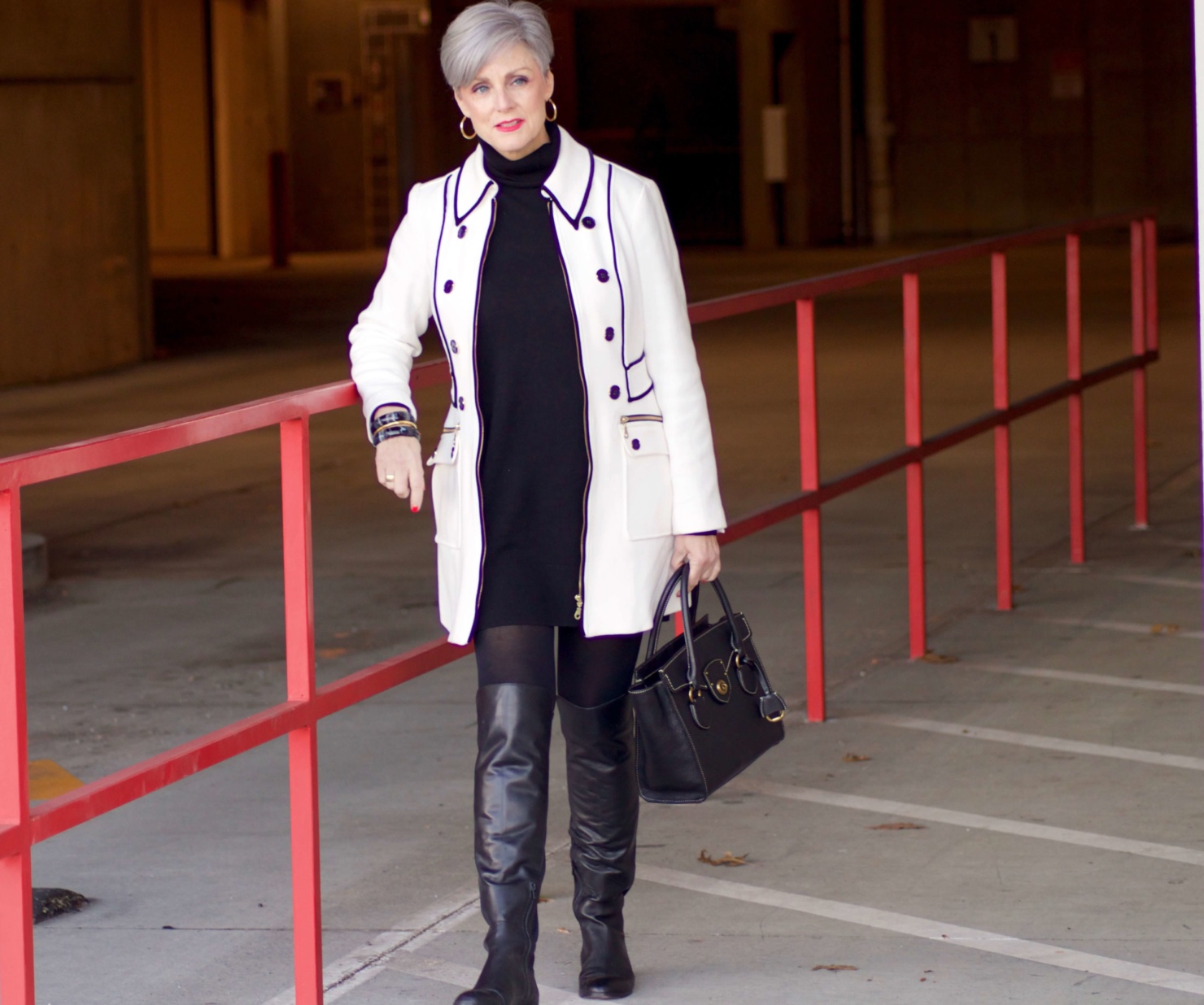 beth from Style at a Certain Age wears a cashmere turtleneck dress, black over the knee boots, and ivory and black coat