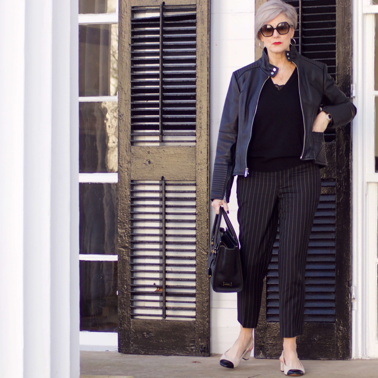 beth from Style at a Certain Age wears Ralph Lauren pinstripe pants, Everlane cashmere sweater, black leather moto jacket, and cap toe slingbacks