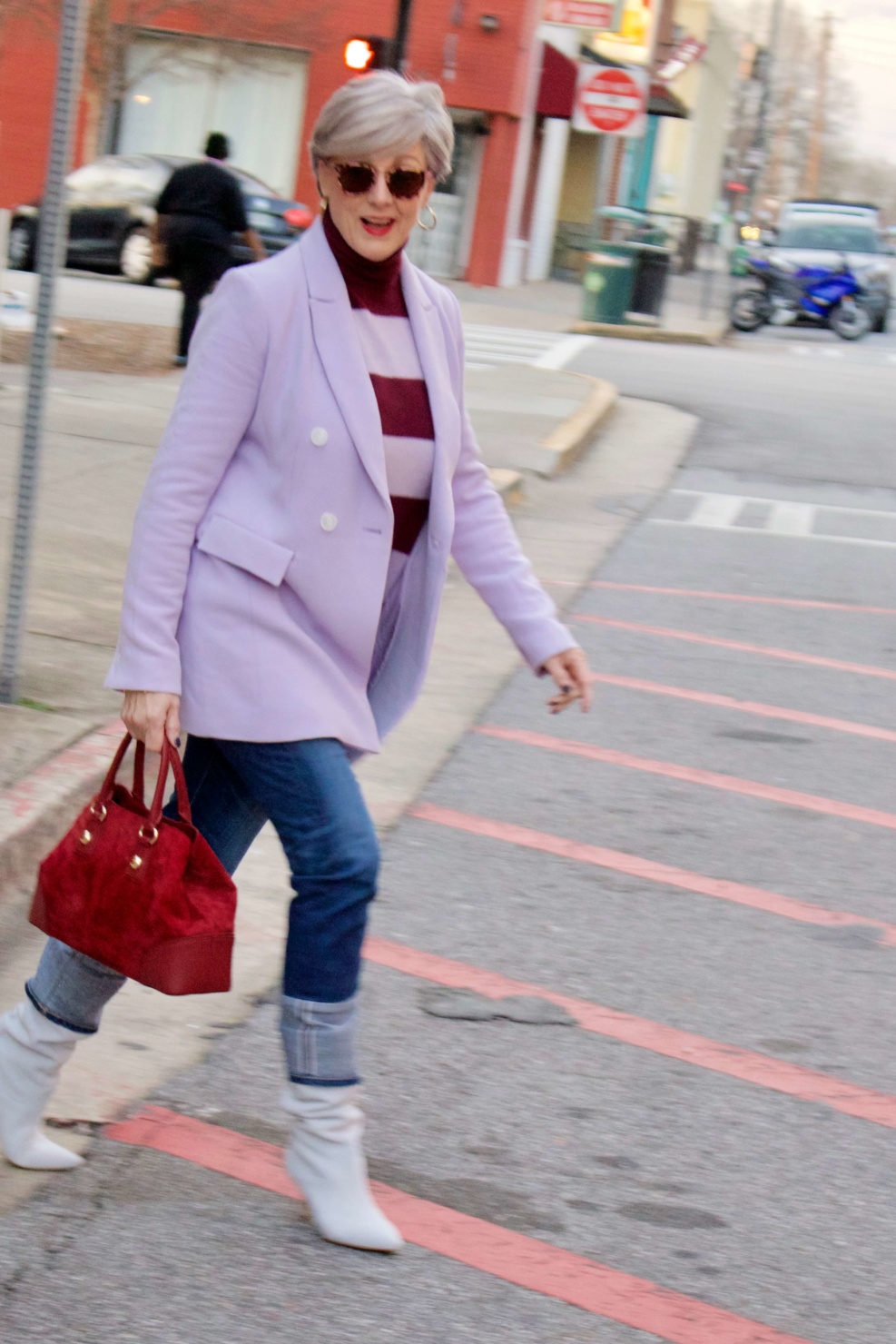 beth from Style at a Certain Age wears a striped turtleneck, lilac blazer, cuffed denim, grey suede boots