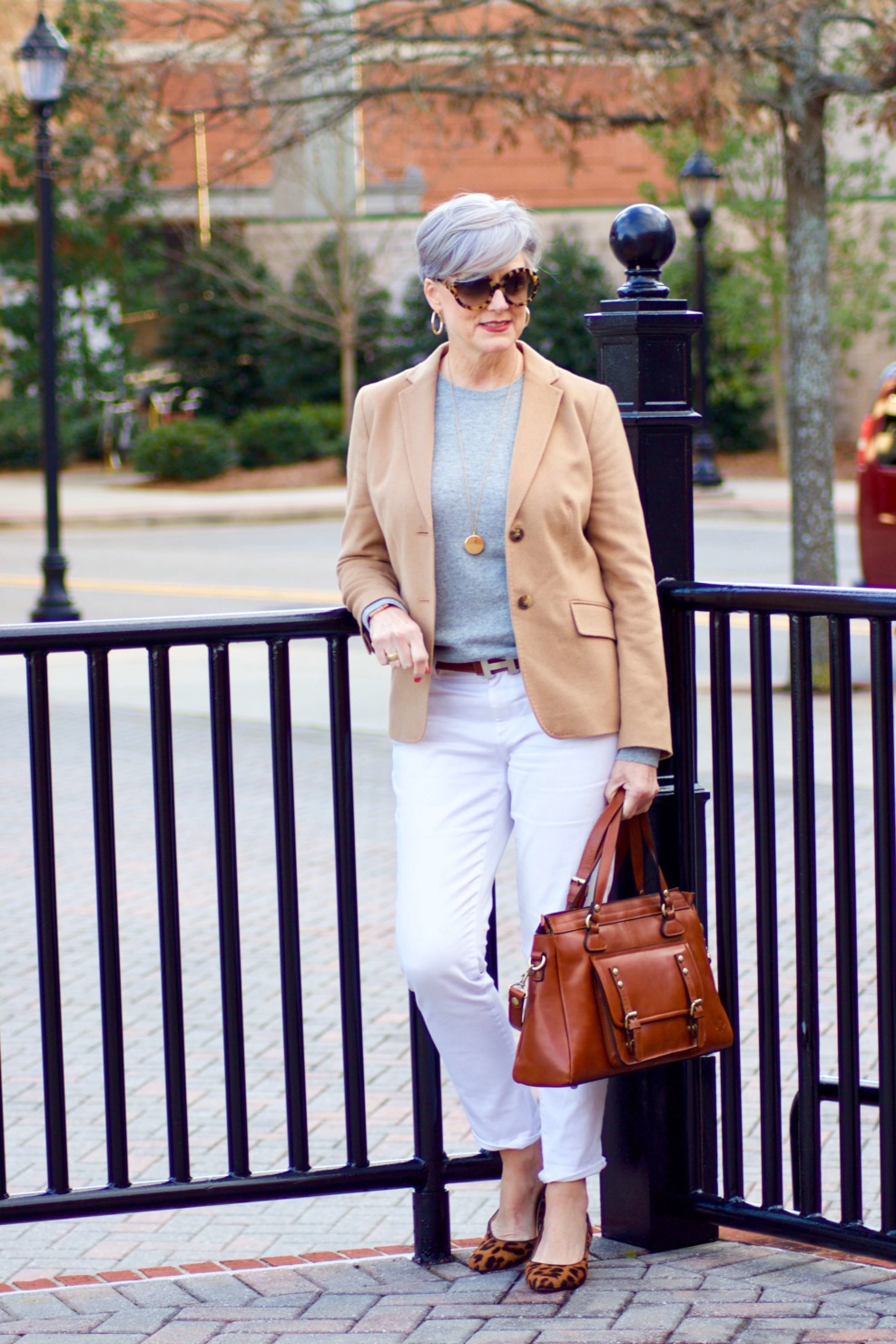 beth from Style at a Certain Age wears a camel blazer, grey cashmere crewneck, white denim, and leopard shoes