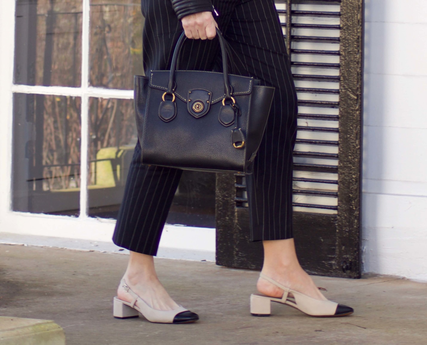 beth from Style at a Certain Age wears Ralph Lauren pinstripe pants, Everlane cashmere sweater, black leather moto jacket, and cap toe slingbacks