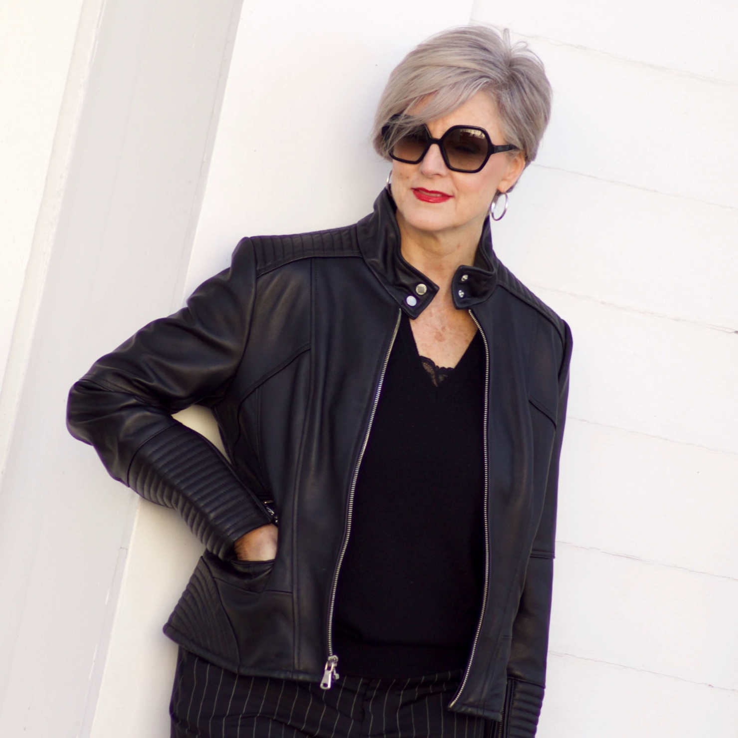 beth from Style at a Certain Age wears Ralph Lauren pinstripe pants, Everlane cashmere sweater, black leather moto jacket, and cap toe slingbacks