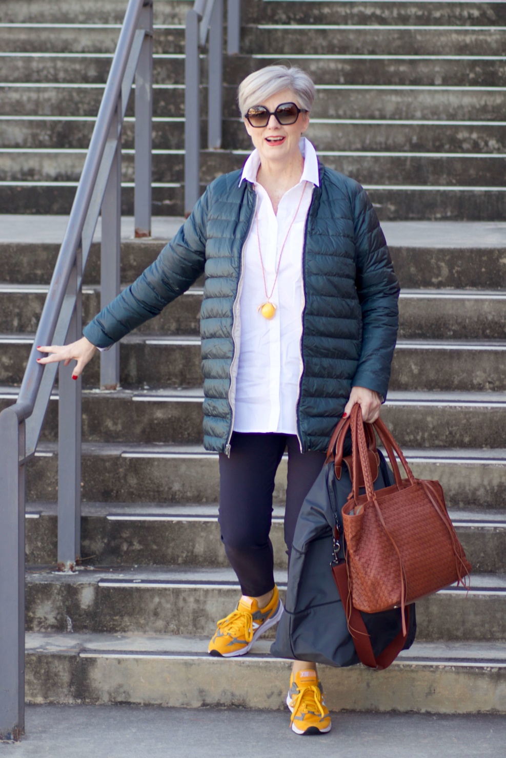 beth from Style at a Certain Age wears Athleta pants, white shirt, puffer jacket, and sneakers