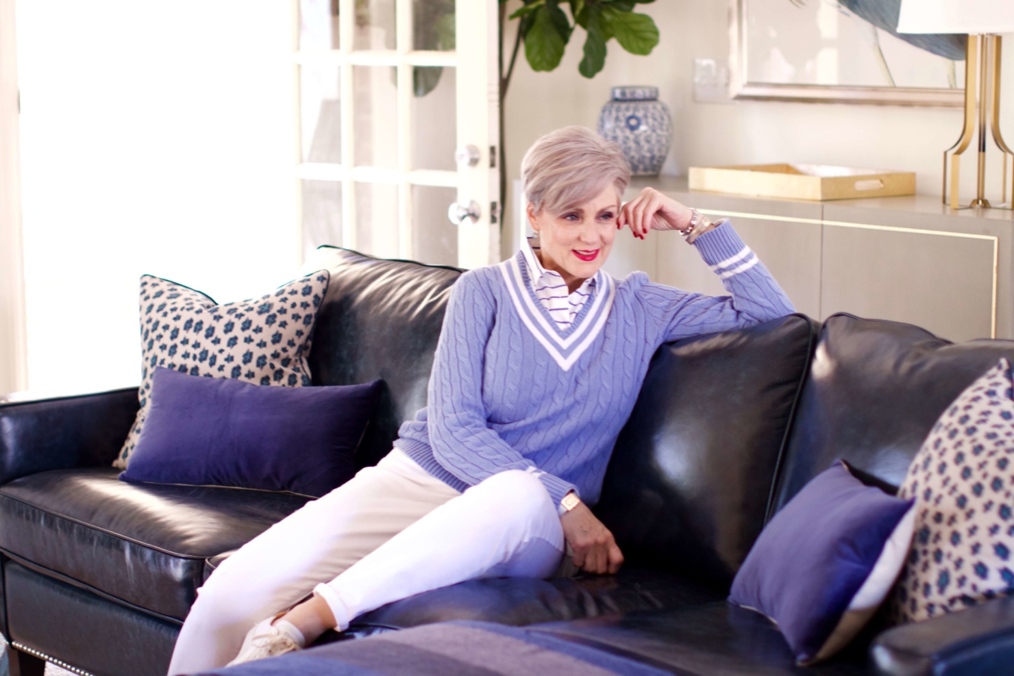 beth from Style at a Certain Age wears a Ralph Lauren cricket sweater, white denim and white tennis shoes
