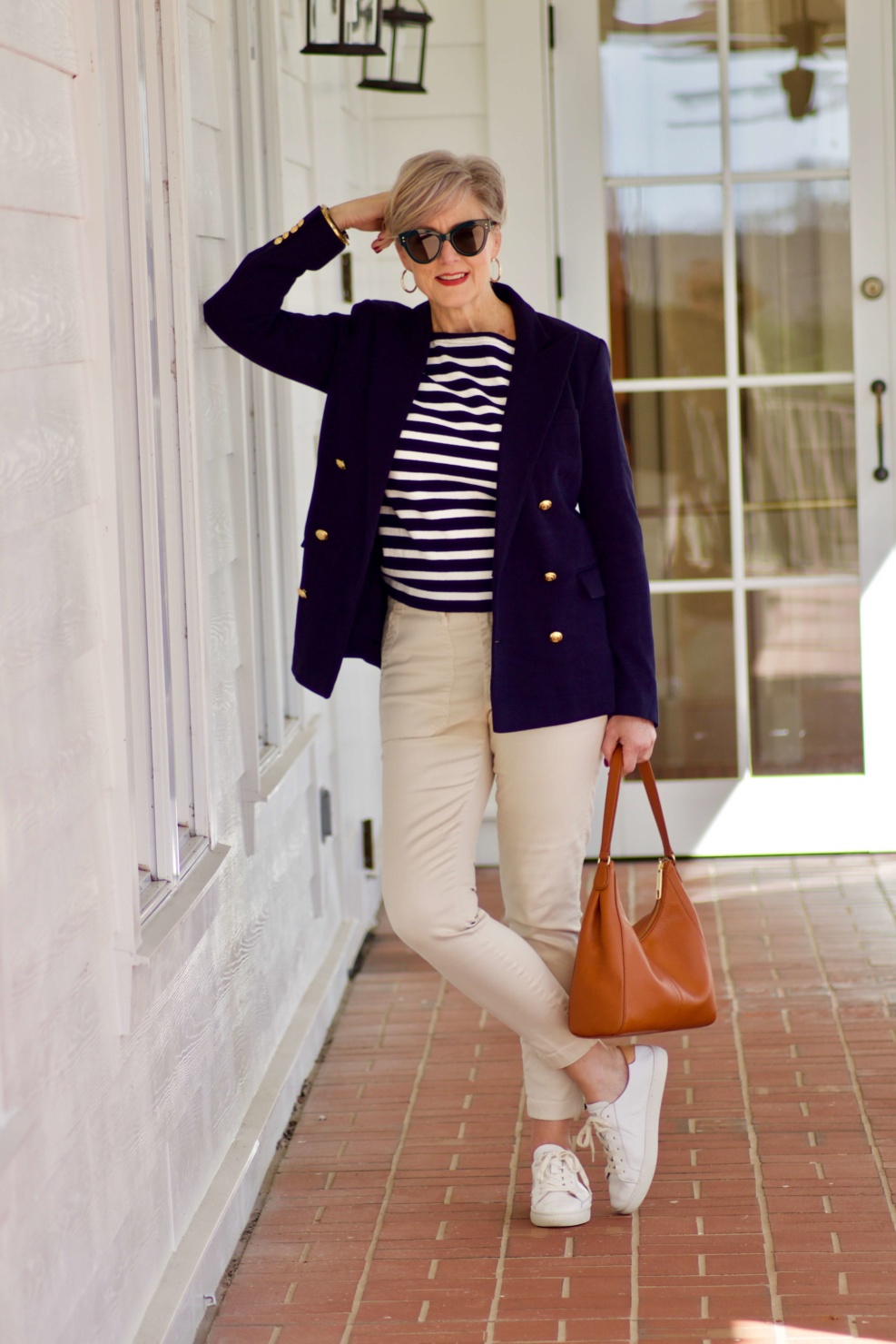 beth from Style at a Certain Age wears J.Crew striped tee, chinos, Ralph Lauren navy blue knit blazer, and white sneakers
