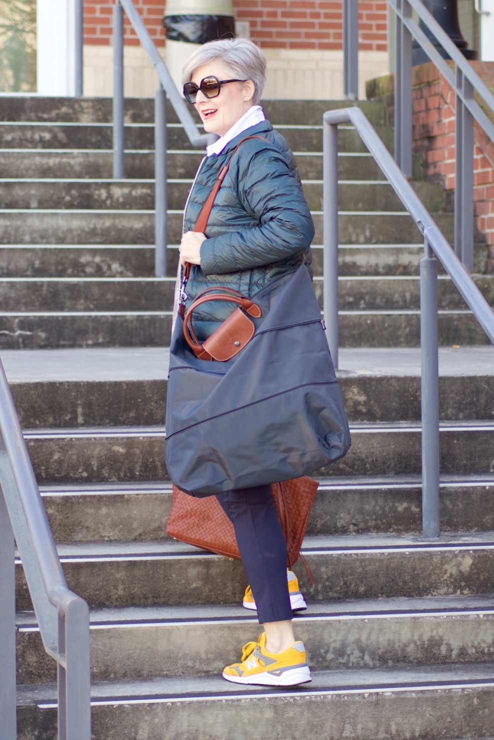 beth from Style at a Certain Age wears Athleta pants, white shirt, puffer jacket, and sneakers