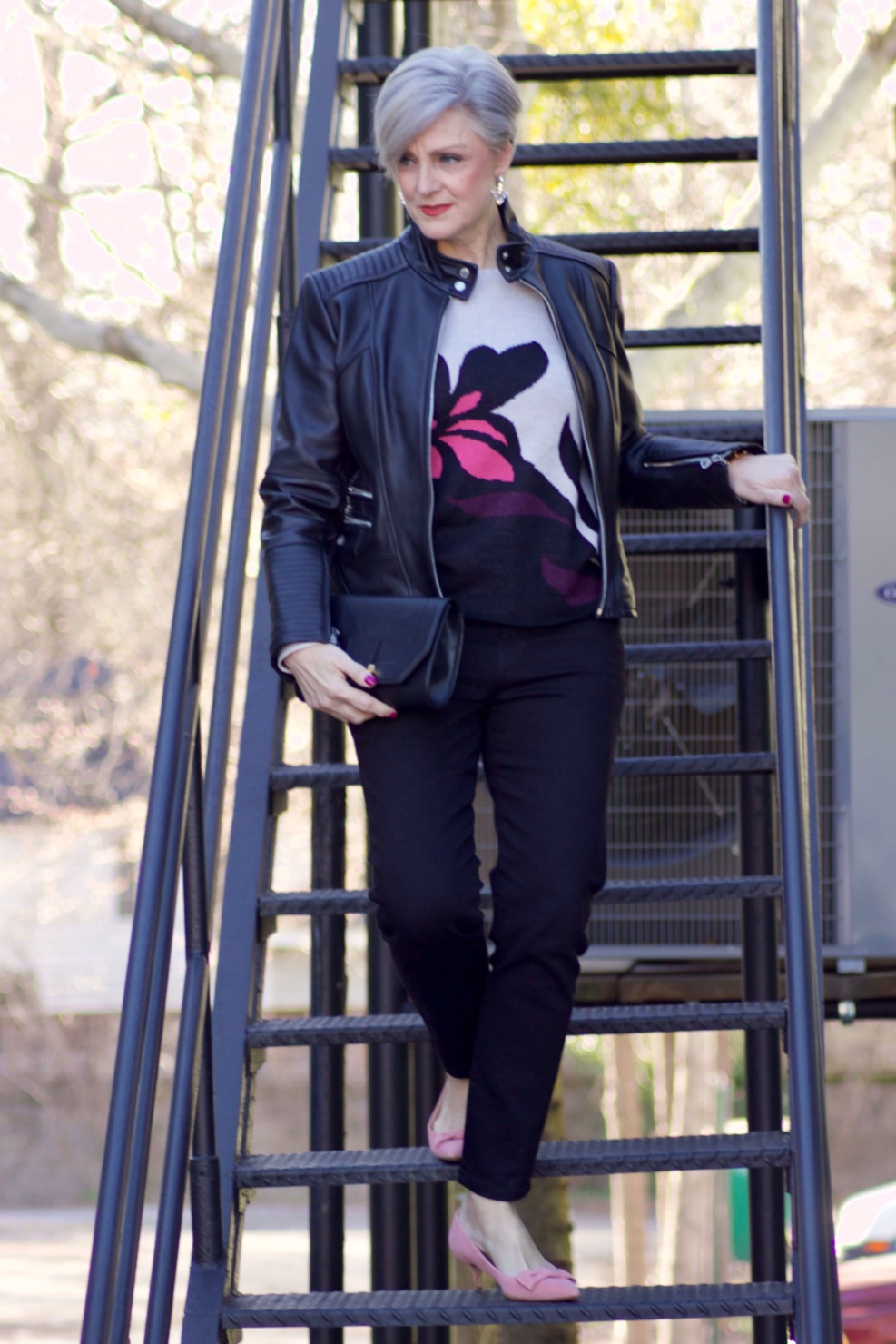 beth from Style at a Certain Age wears a floral jacquard sweater, black skinny jeans, black leather moto jacket and pink suede pumps for date night