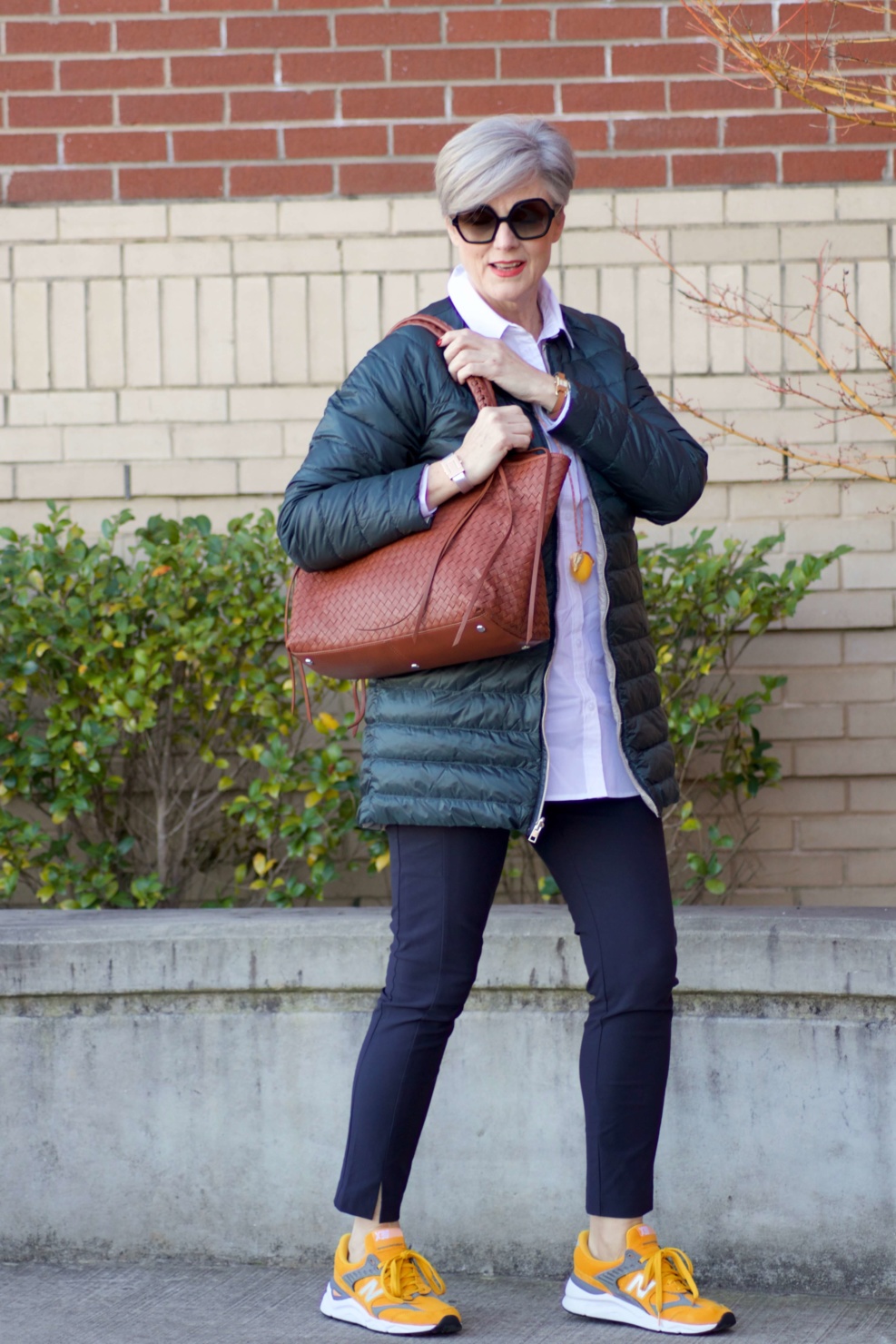 beth from Style at a Certain Age wears Athleta pants, white shirt, puffer jacket, and sneakers
