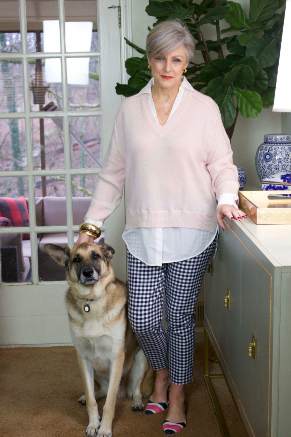 beth from Style at a Certain Age wears a paloma pink sweater with white underlay, gingham pants, and pointy toe flats