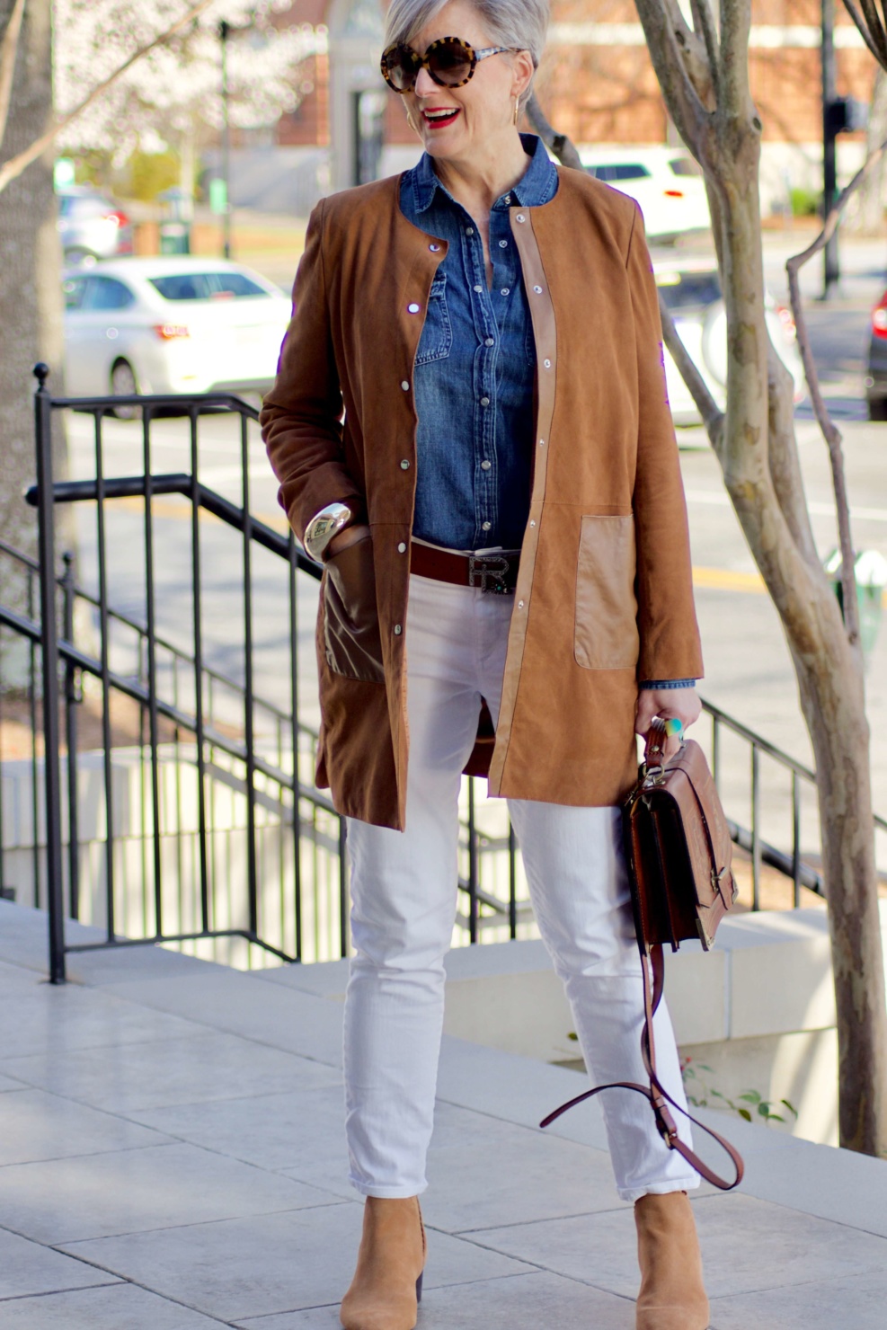 beth from Style at a Certain Age wears white denim, chambray shirt, suede jacket and booties