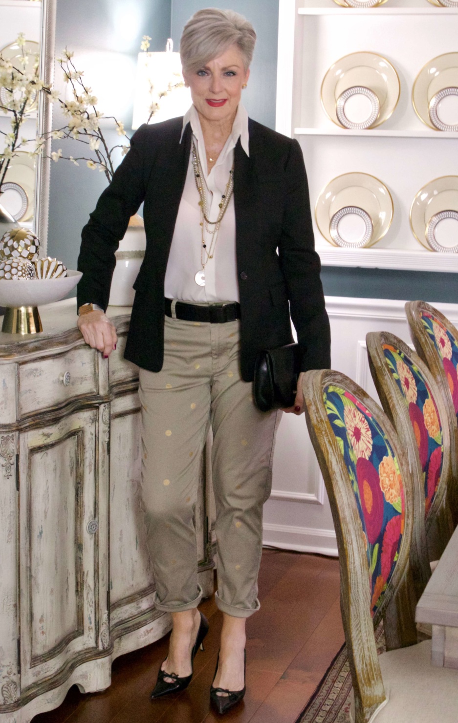beth from Style at a Certain Age wears J.Crew chinos, black blazer, ivory silk blouse, black pumps and black clutch handbag