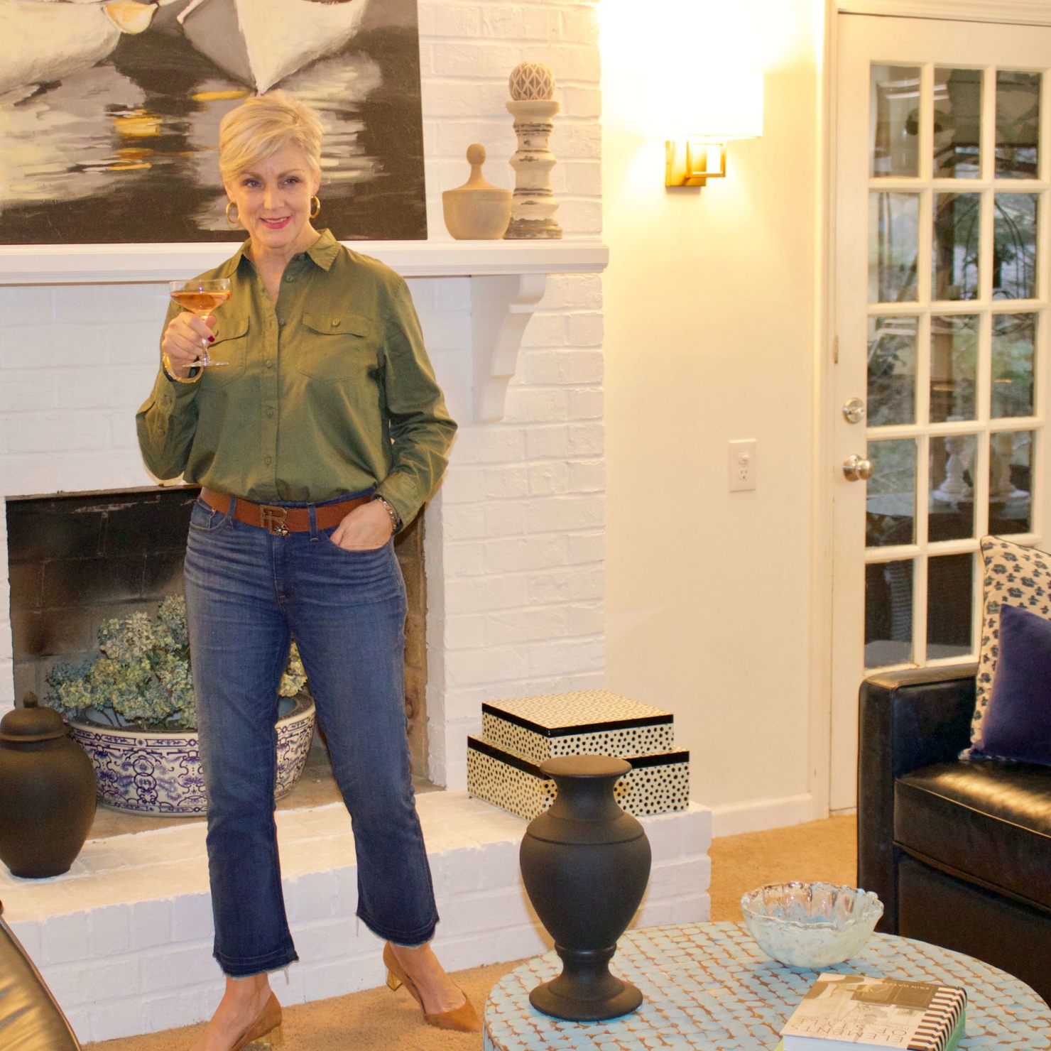 beth from Style at a Certain Age wears a green utility shirt, frayed denim, and suede block heel shoes